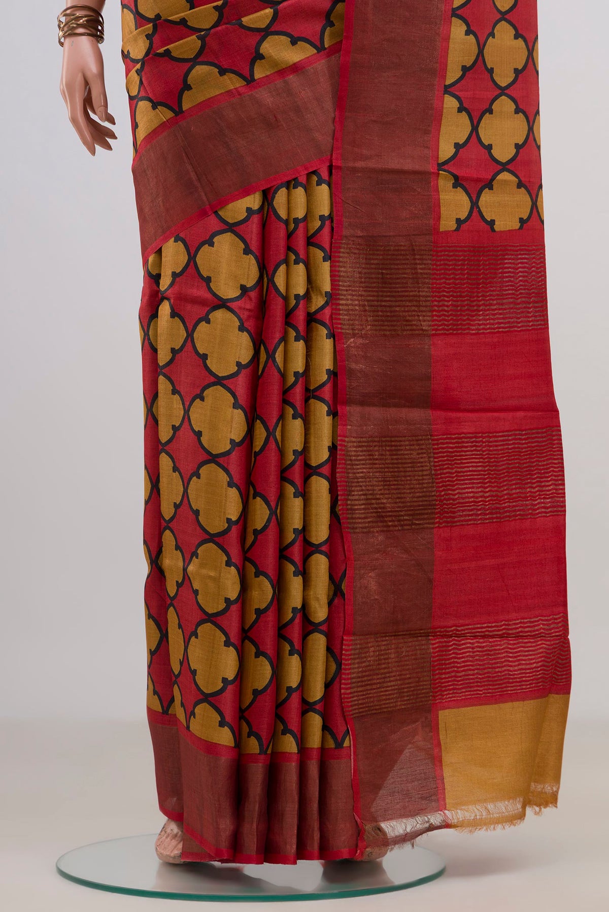 Pleats and pallu of Red Tussar Saree with Printed design on the body and Zari Border. 