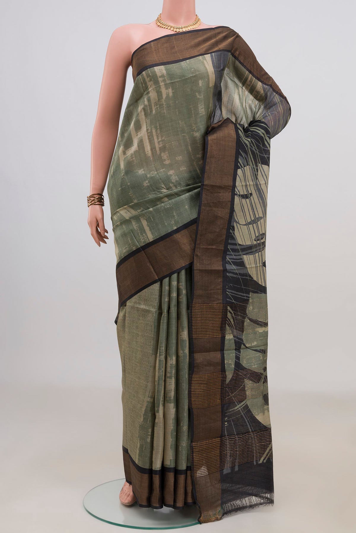 Green Tussar Saree with Printed design on the body and Zari Border.  displayed on a mannequin