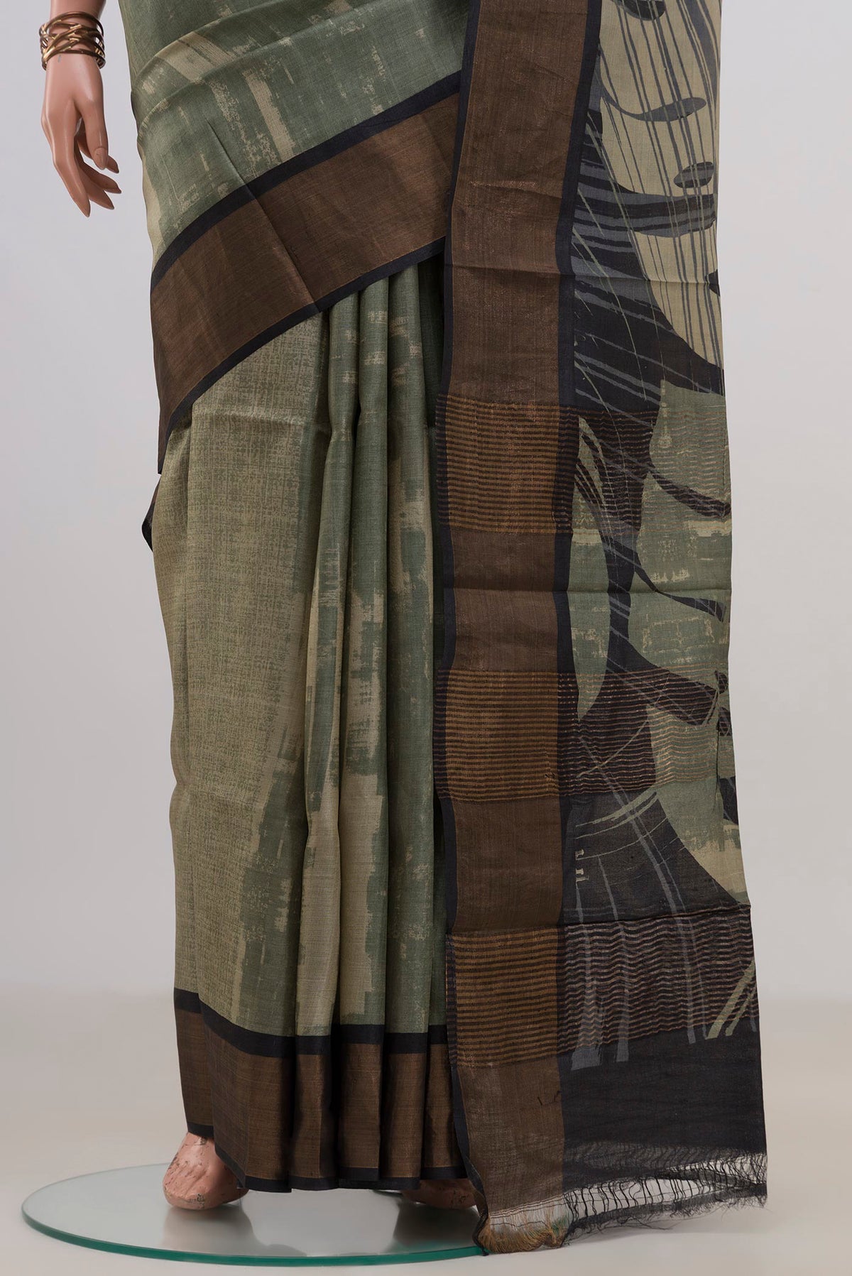 Pleats and pallu of Green Tussar Saree with Printed design on the body and Zari Border. 
