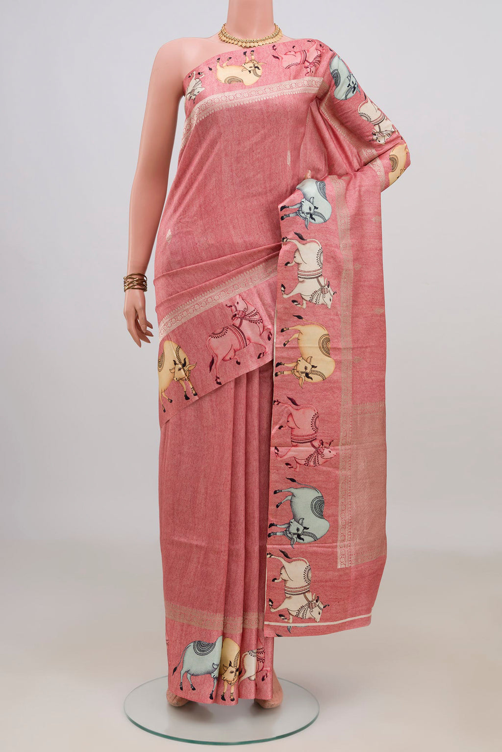 Peach Tussar Saree with Zari Butta on the body and Fancy Border.  displayed on a mannequin