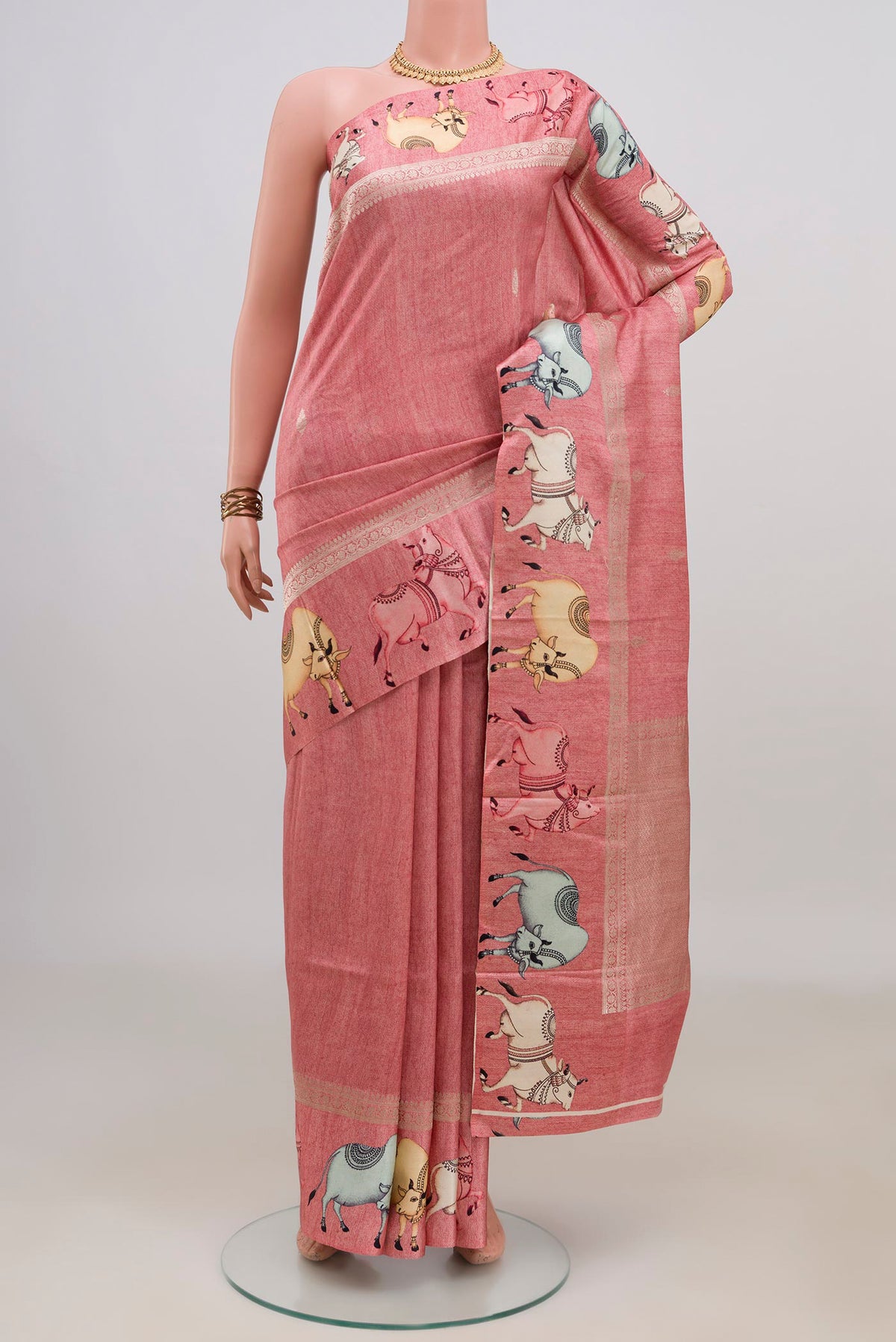 Peach Tussar Saree with Zari Butta on the body and Fancy Border.  displayed on a mannequin