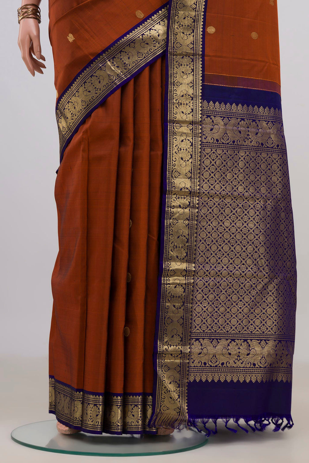 Pleats and pallu of Pure Silk Rust Kanjivaram Saree with Zari Butta on the body and Zari Border. 