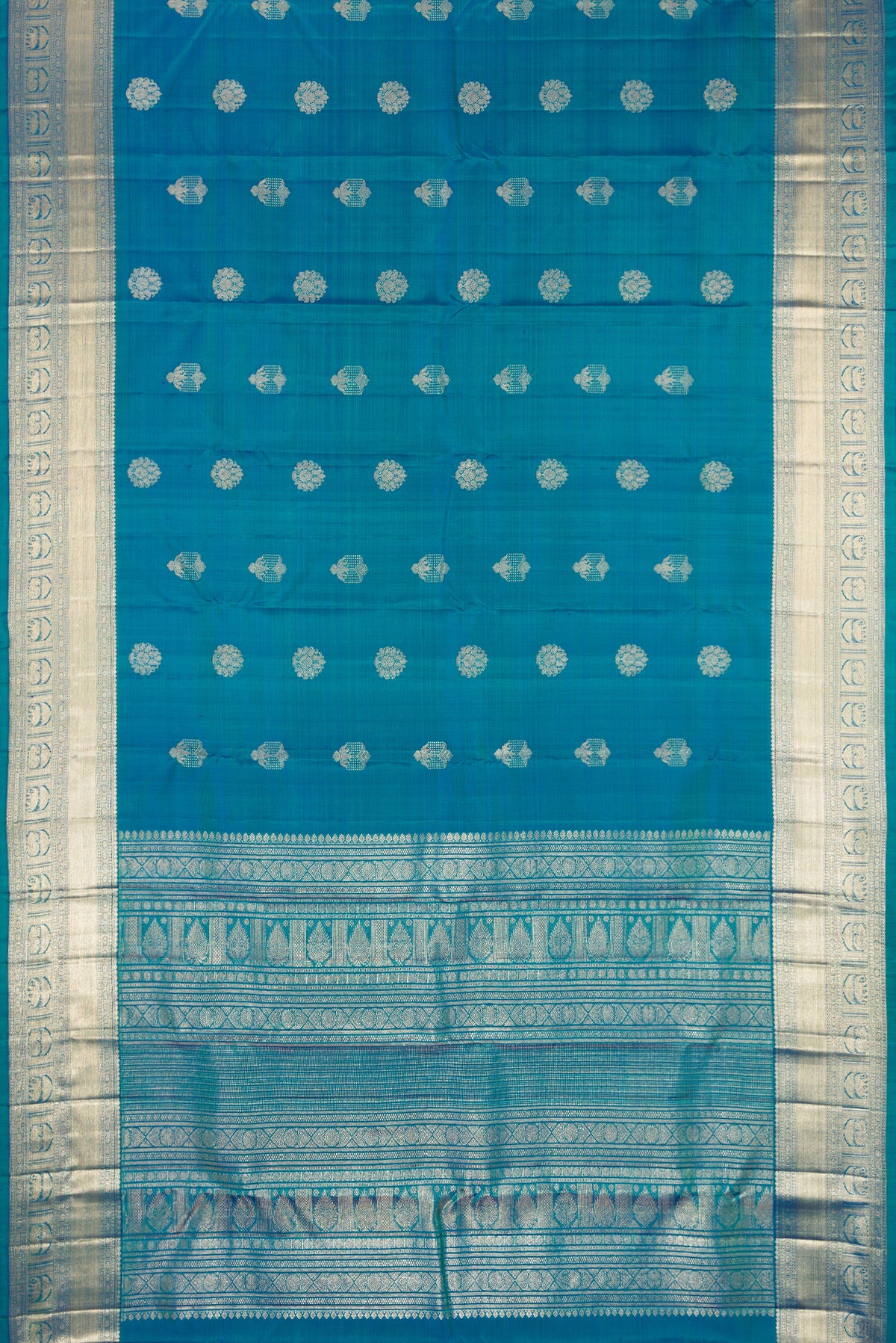 Peacock Blue Dual Tone Kanchipuram Silk Saree with Zari Butta on the body and Zari Border.  displayed on a mannequin