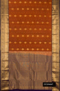 Rust Dual Tone Kanchipuram Silk Saree with Zari Butta on the body and Zari Border.  displayed on a mannequin