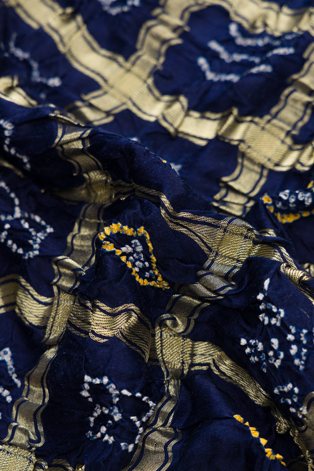Close up of Navy Blue Dual Tone Bandhani Silk Saree with Bandhani Print on the body and Without Border.  displaying folds