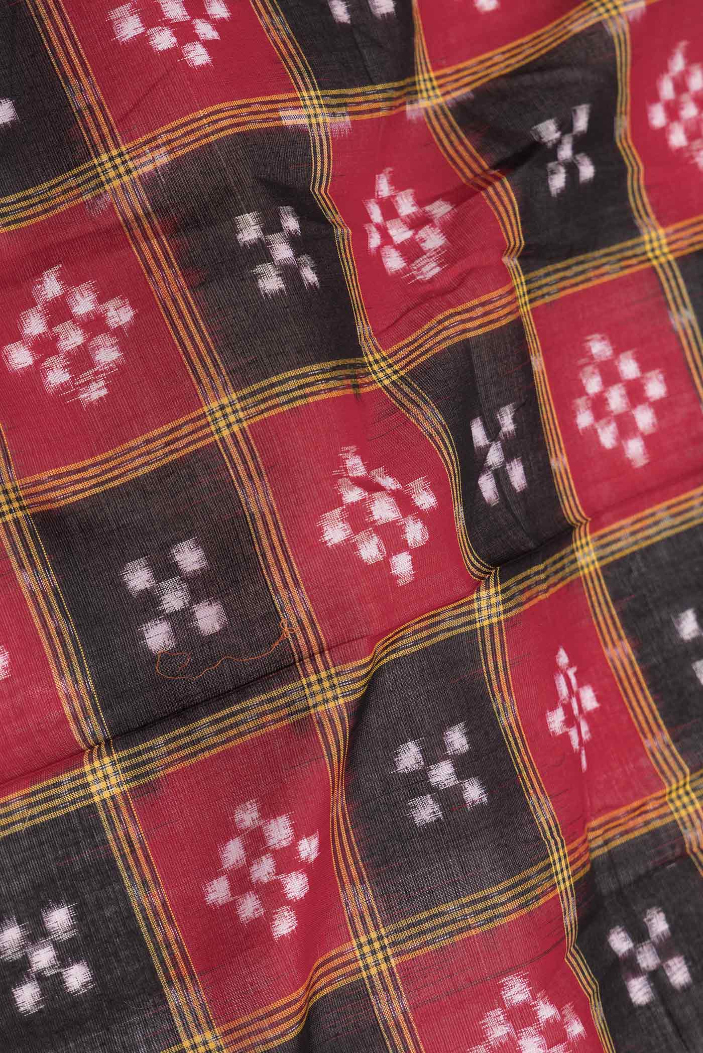 Close up of Red and Black Color Double Ikat Saree with Ikat Print on the body and Thread Border displaying folds