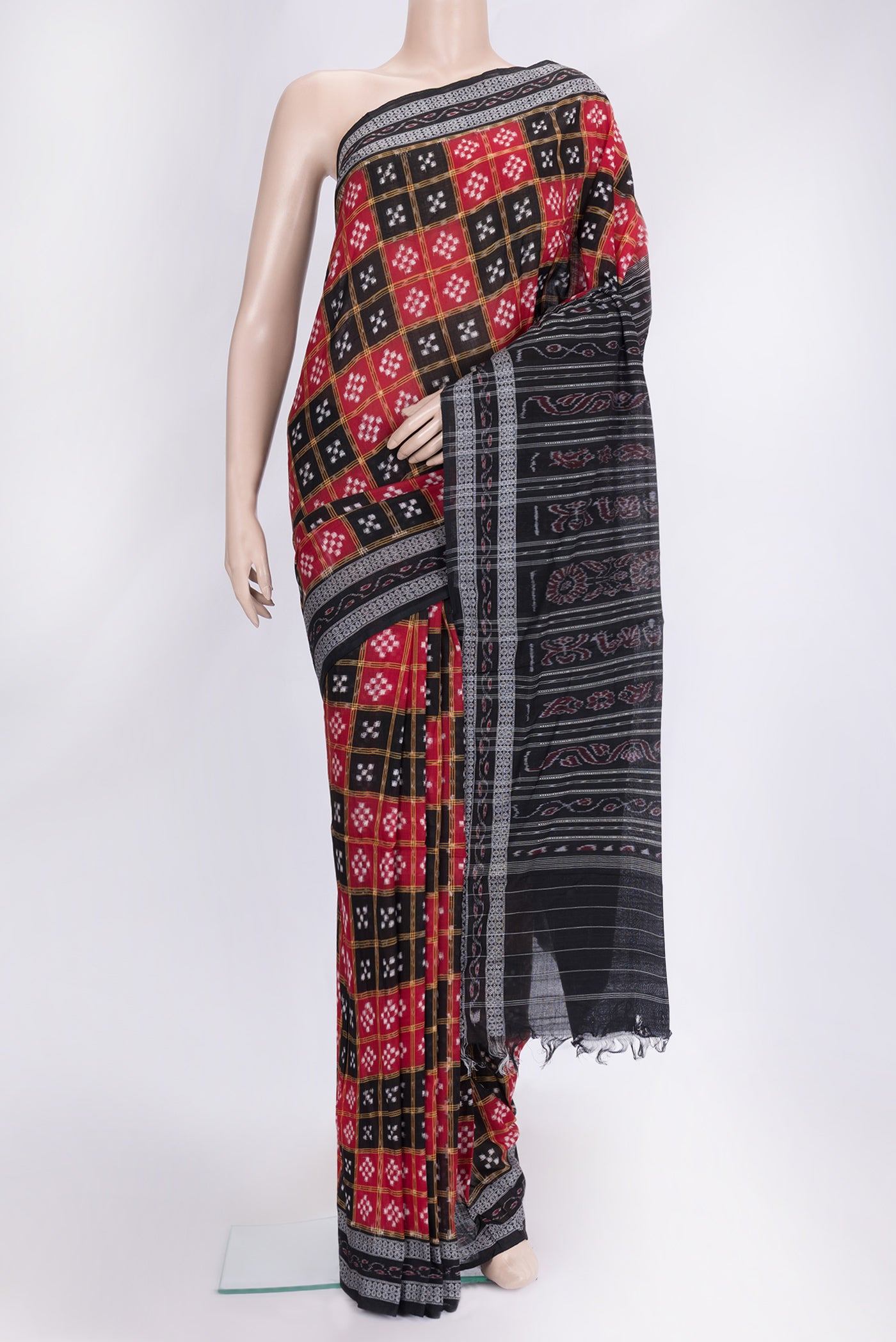 Black and Red Color Double Ikat Saree with Ikat Print on the body and Thread Border.  displayed on a mannequin