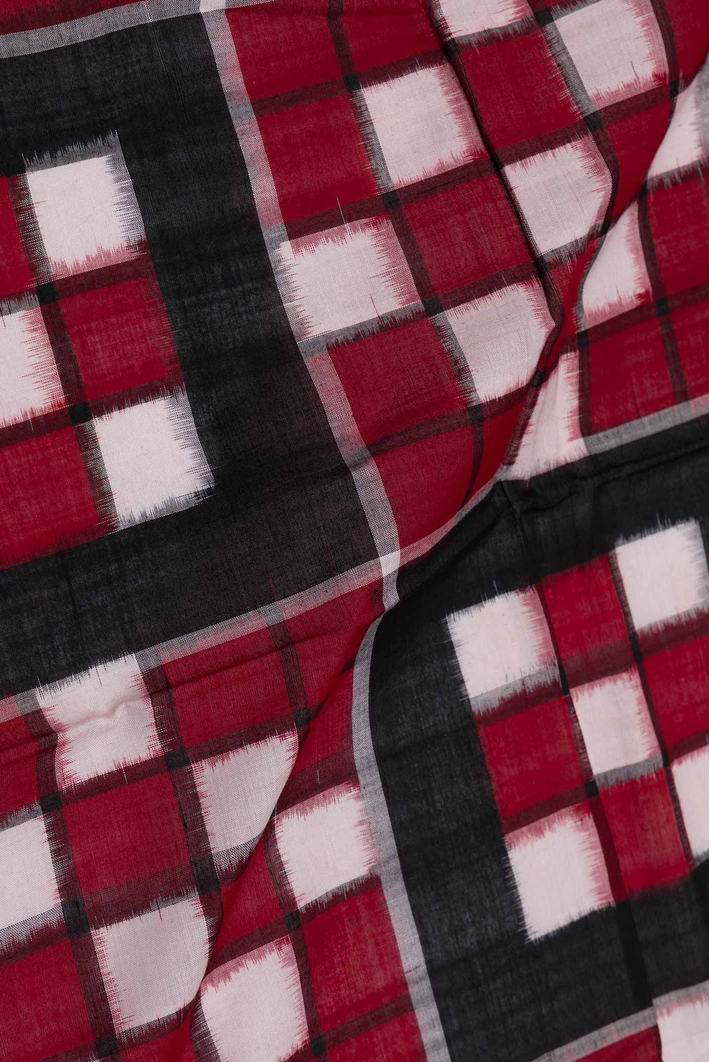 Close up of Black and Maroon Color Double Ikat Saree with Ikat Print on the body and Ikat Border displaying folds