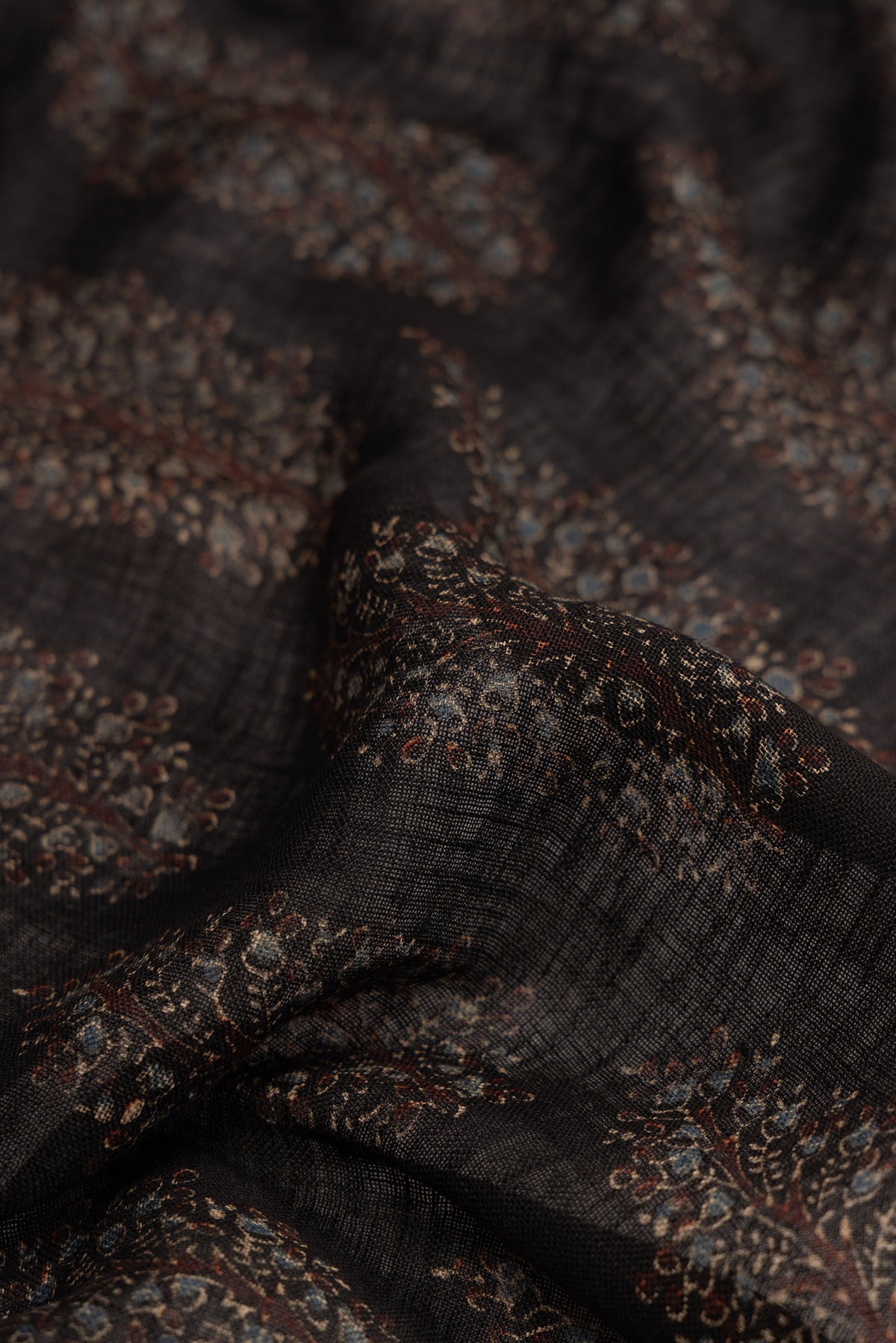 Close up of Black Dual Tone Maheshwari Silk Saree with Zari Butta on the body and Zari Border.  displaying folds