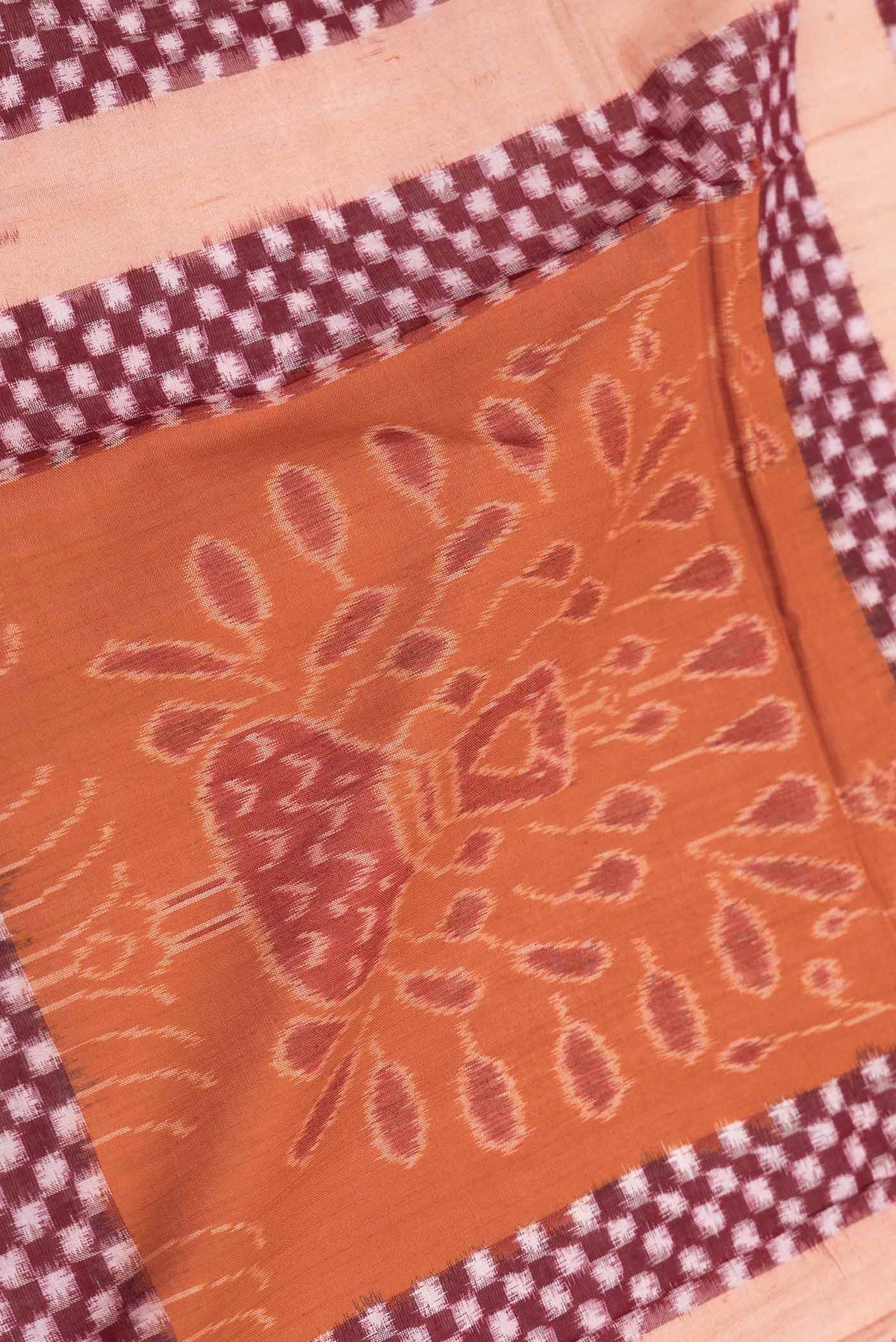 Close up of Orange Dual Tone Double Ikat Saree with Ikat Print on the body and Ikat Border displaying folds