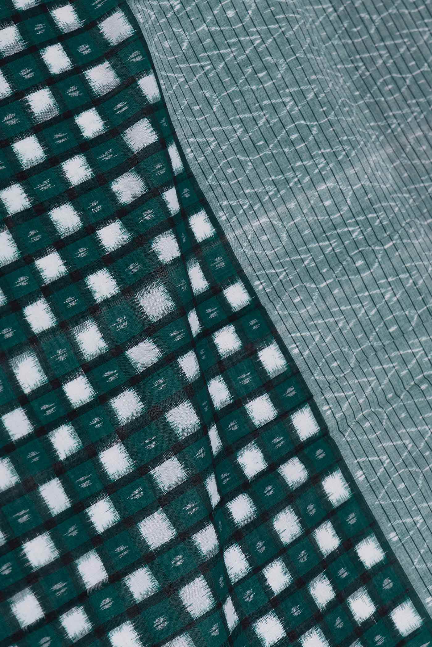 Close up of Green Dual Tone Double Ikat Saree with Ikat Print on the body and Ikat Border displaying folds