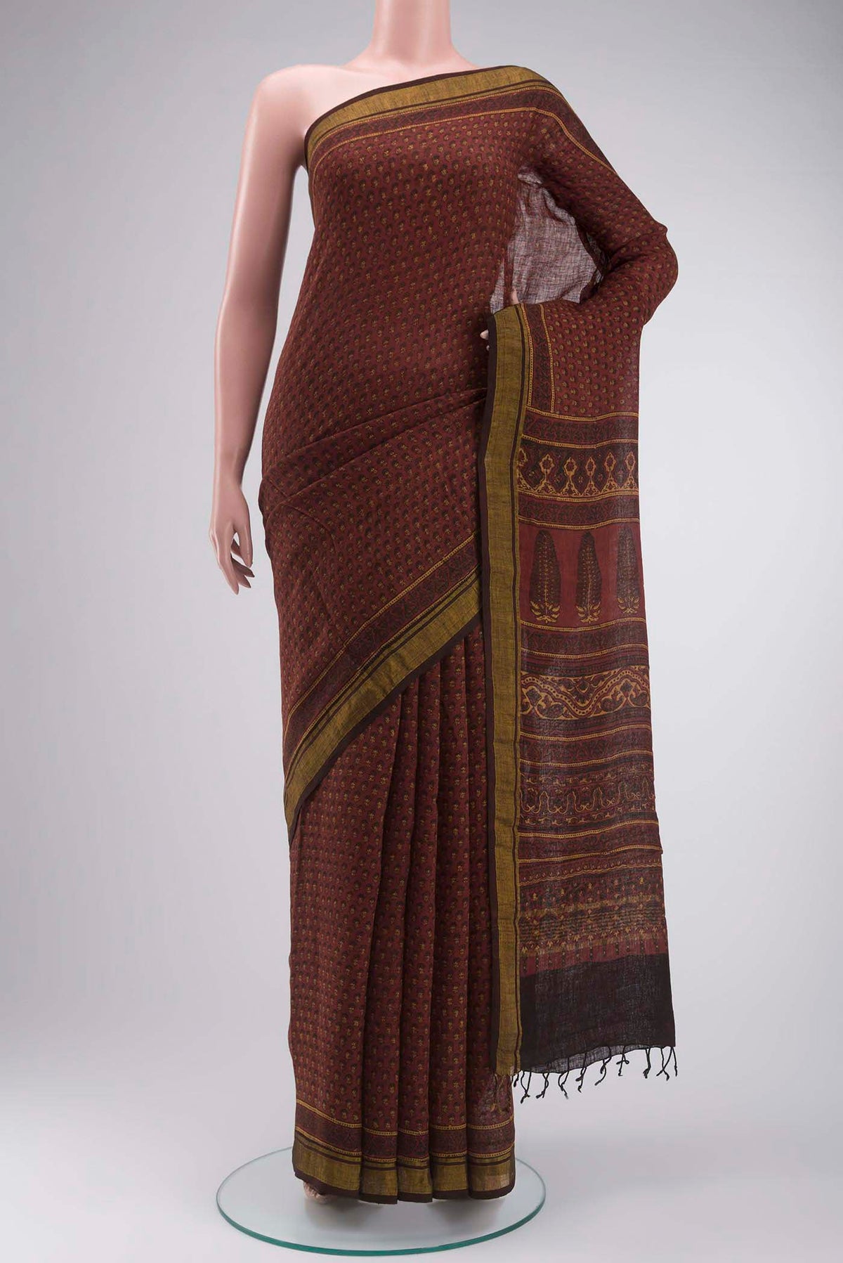 Rust Kalamkari Cotton Saree with Printed design on the body and Zari Border displayed on a mannequin
