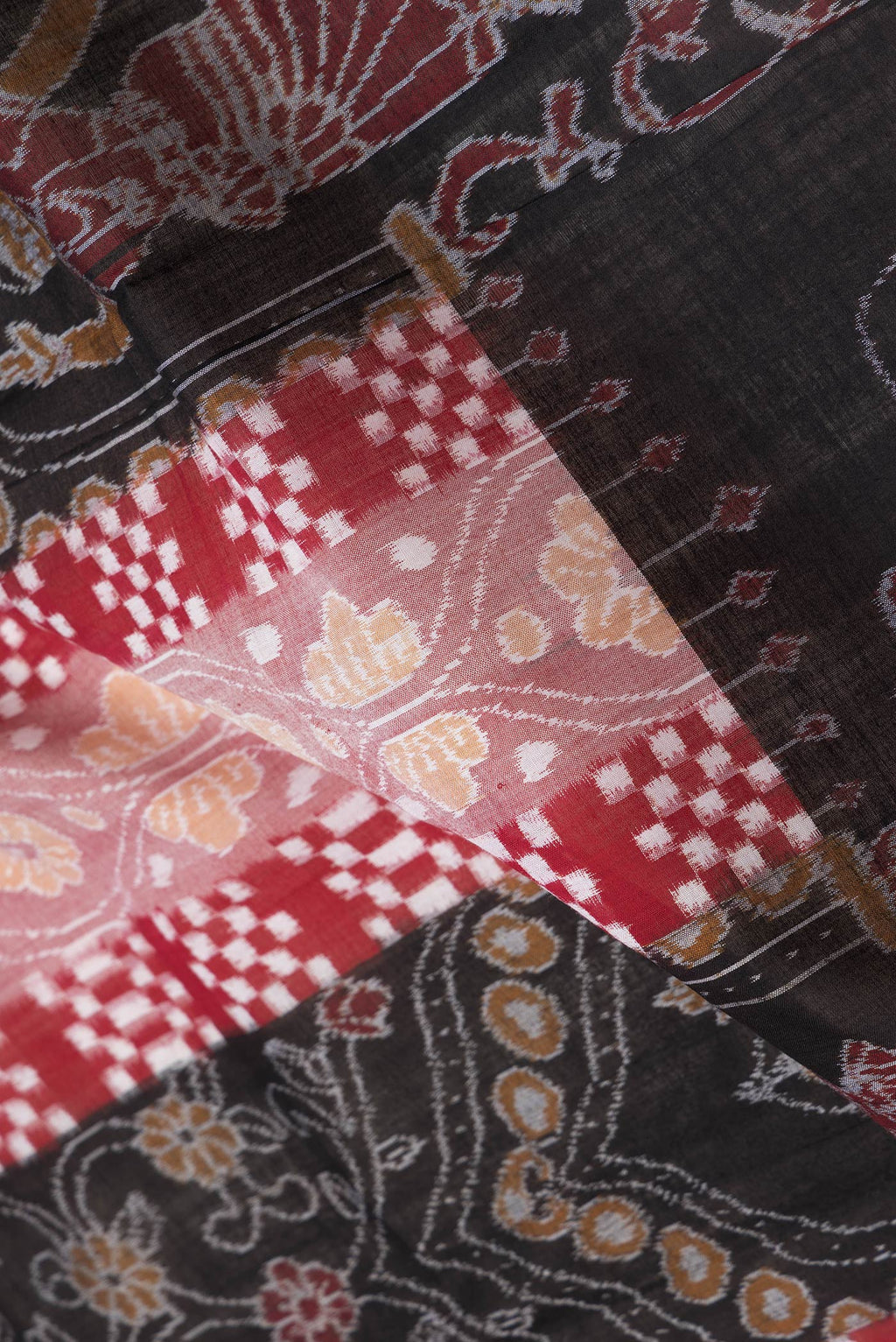 Close up of Black and Maroon Color Double Ikat Saree with Ikat Print on the body and Thread Border.  displaying folds
