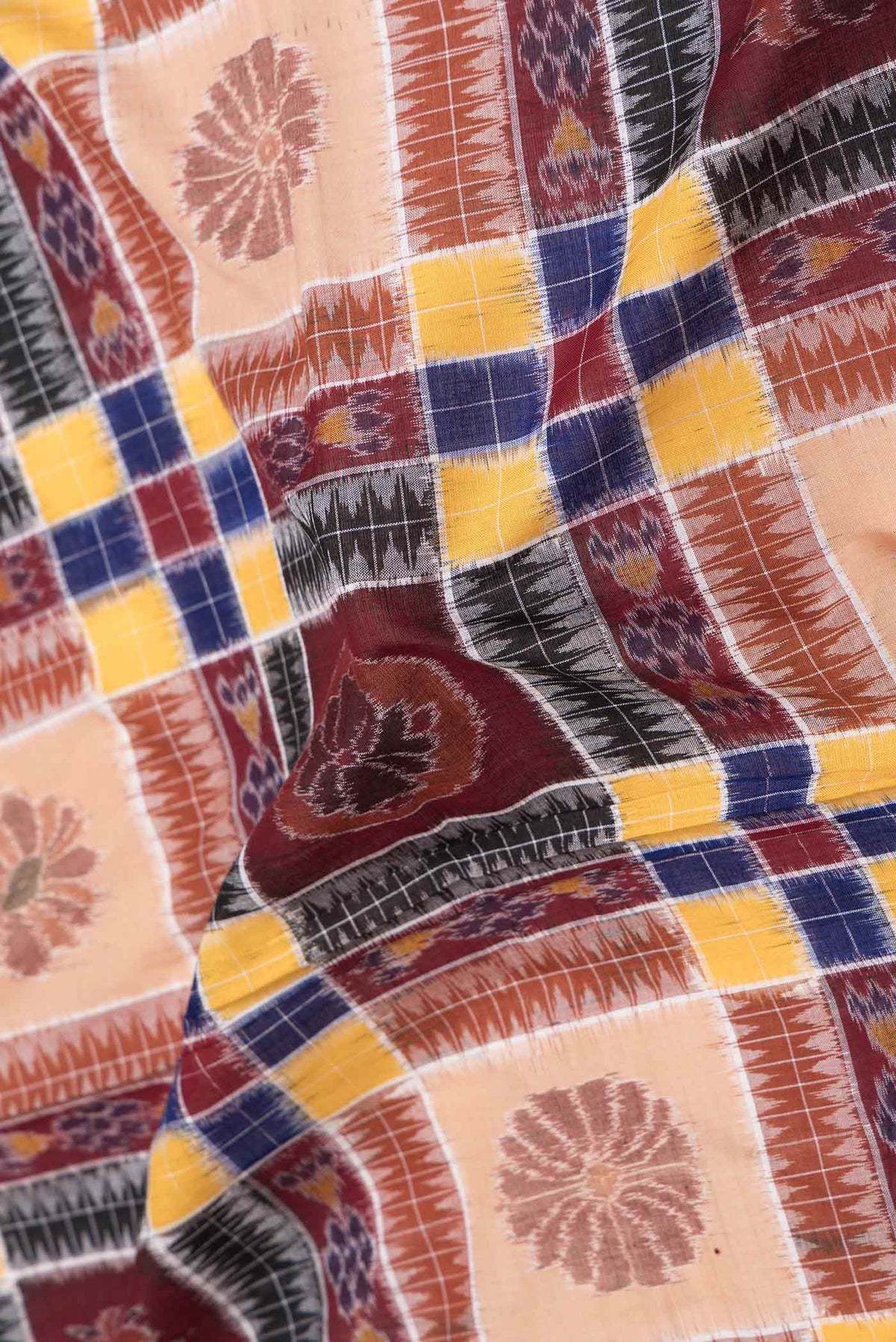 Close up of Maroon and Beige Color Double Ikat Saree with Ikat Print on the body and Ikat Border displaying folds