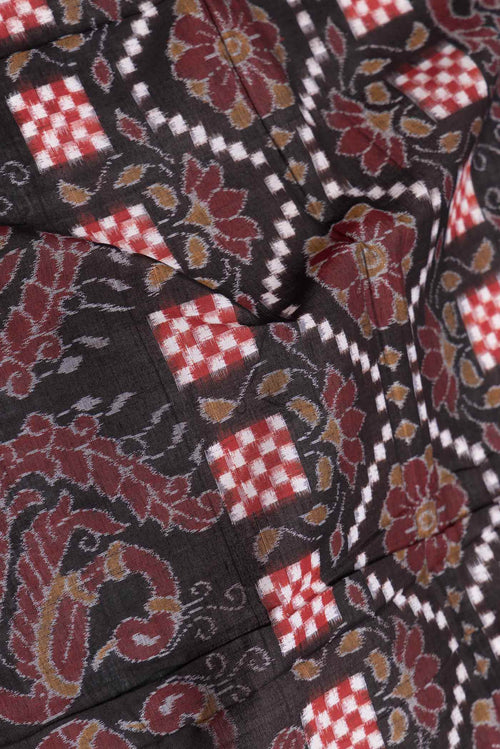 Close up of Black Dual Tone Double Ikat Saree with Ikat Print on the body and Thread Border displaying folds