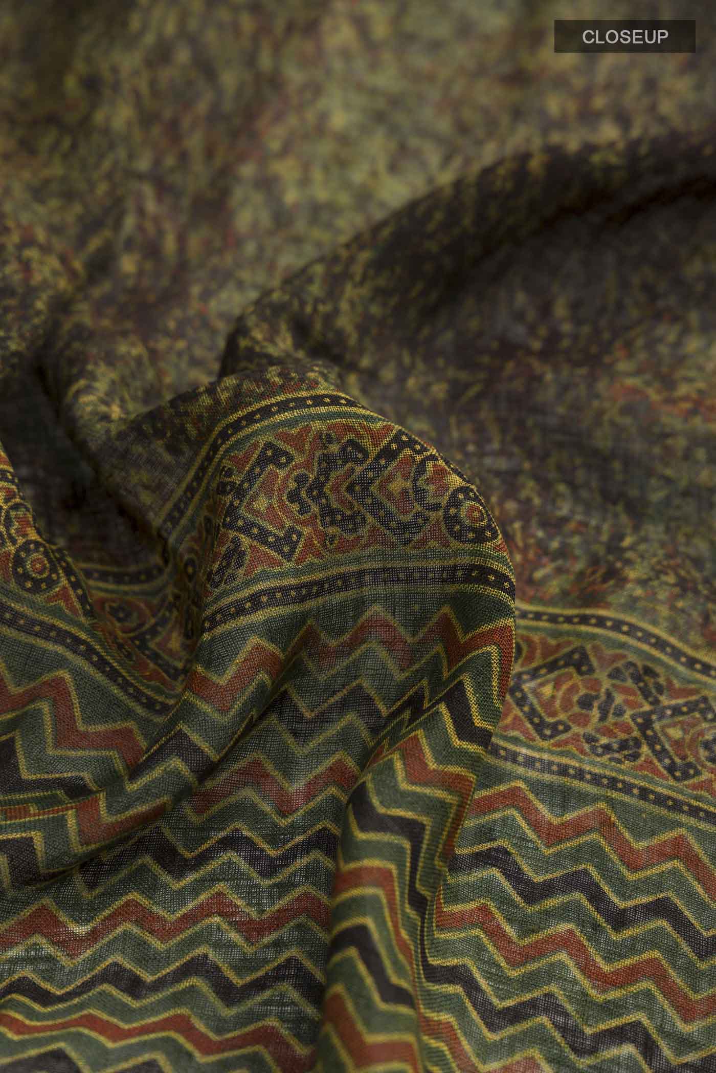 Close up of Green Linen Saree with Printed design on the body and Zari Border displaying folds