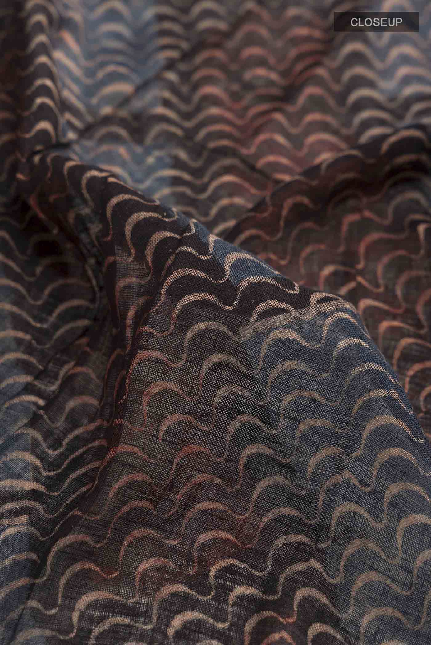 Close up of Black Bhagalpuri Tussar Silk Saree with Printed design on the body and Zari Border displaying folds