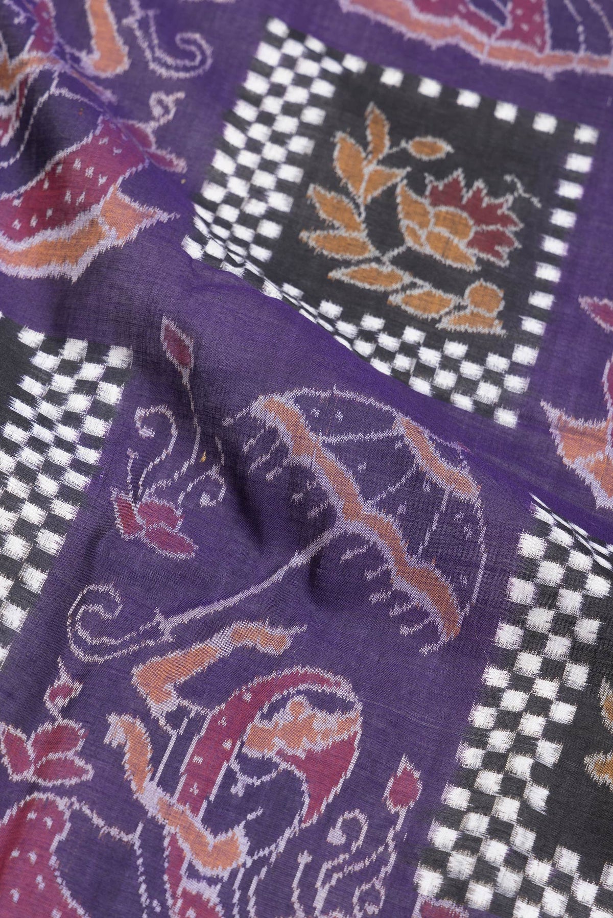 Close up of Purple Dual Tone Double Ikat Saree with Ikat Print on the body and Thread Border.  displaying folds