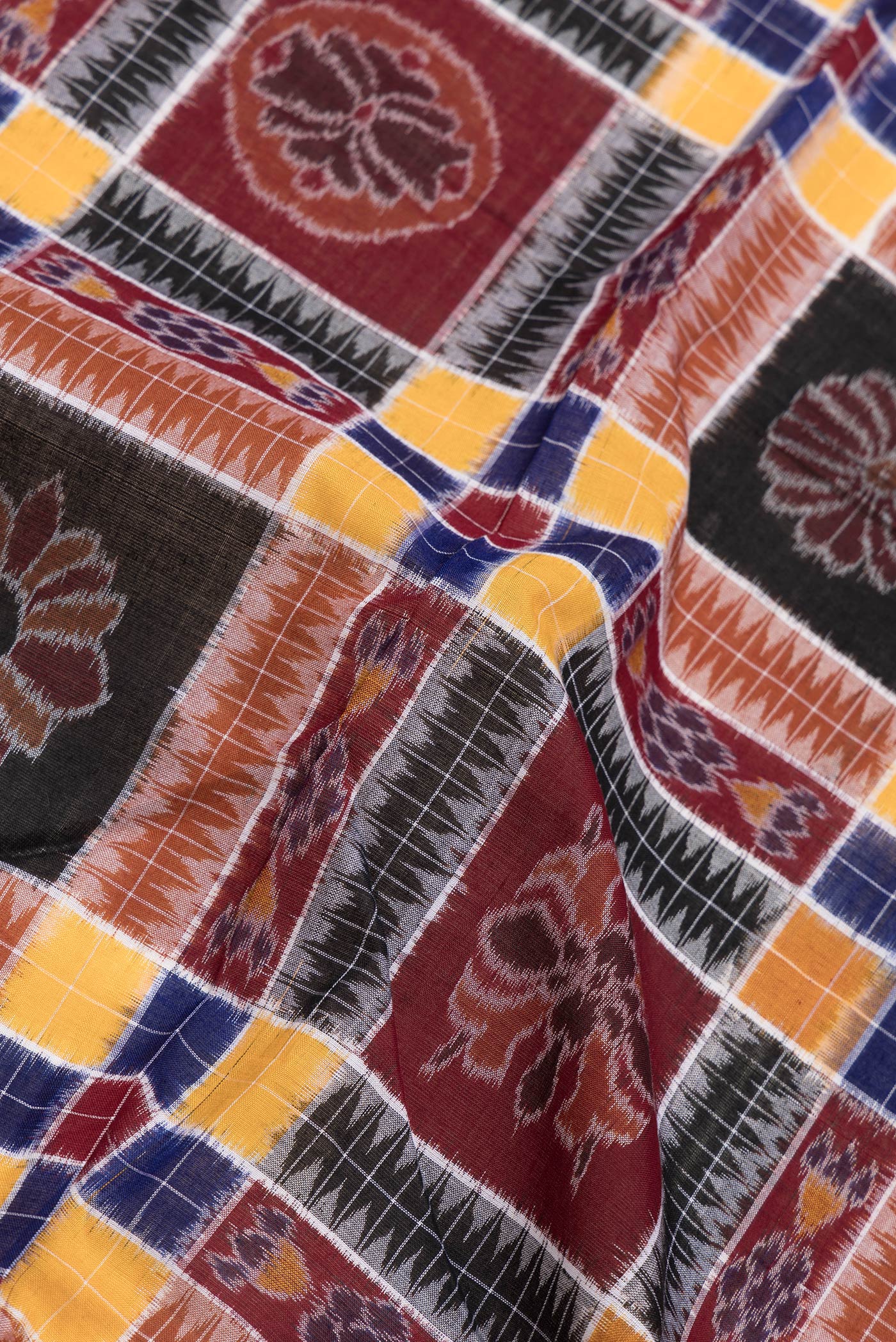 Close up of Black and Maroon Color Double Ikat Saree with Ikat Print on the body and Thread Border.  displaying folds