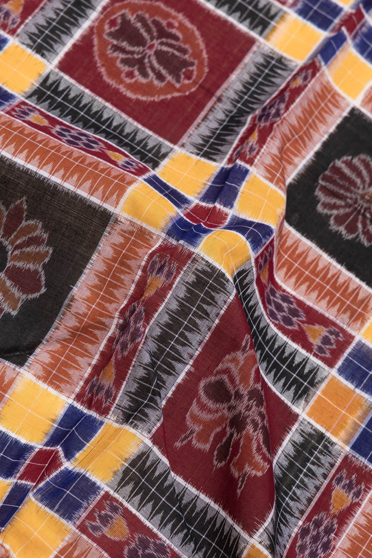 Close up of Black and Maroon Color Double Ikat Saree with Ikat Print on the body and Thread Border.  displaying folds
