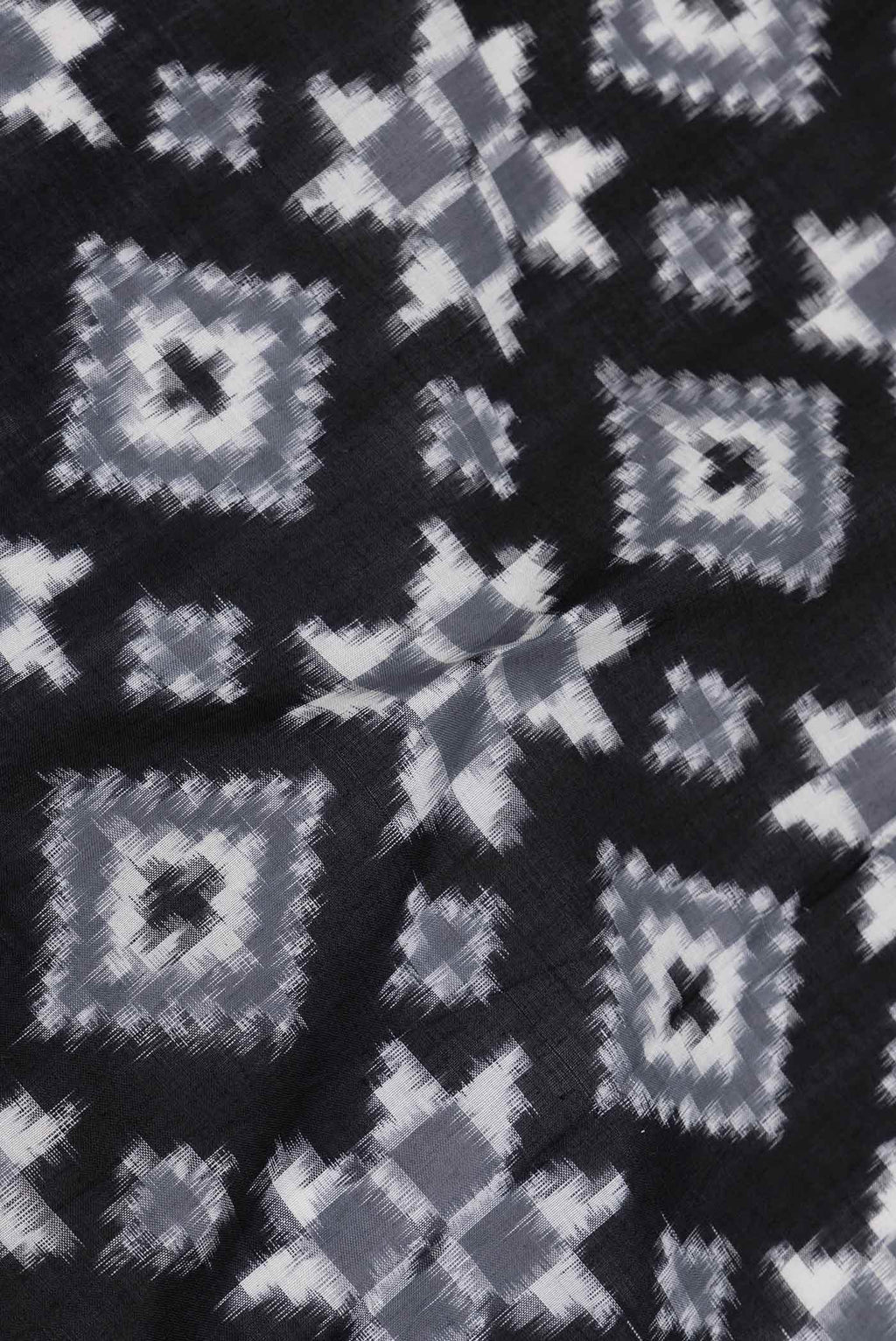 Close up of Black Dual Tone Double Ikat Saree with Ikat Print on the body and Plain Border displaying folds