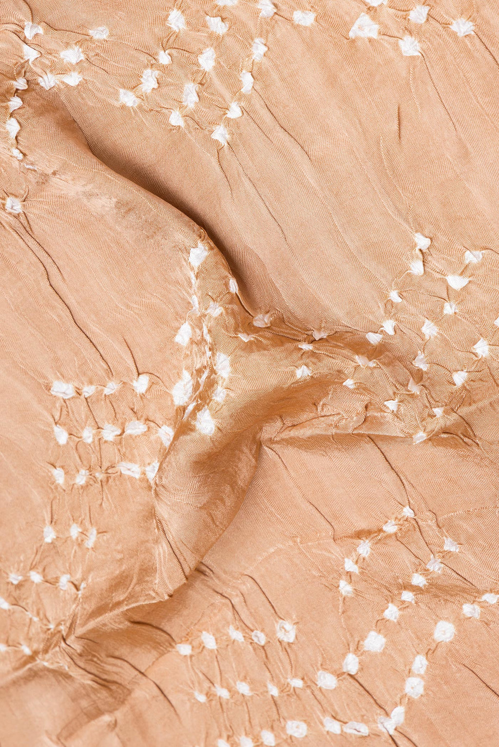 Close up of Beige Blended Satin Crepe Saree with Bandhani Print on the body and Printed Border.  displaying folds