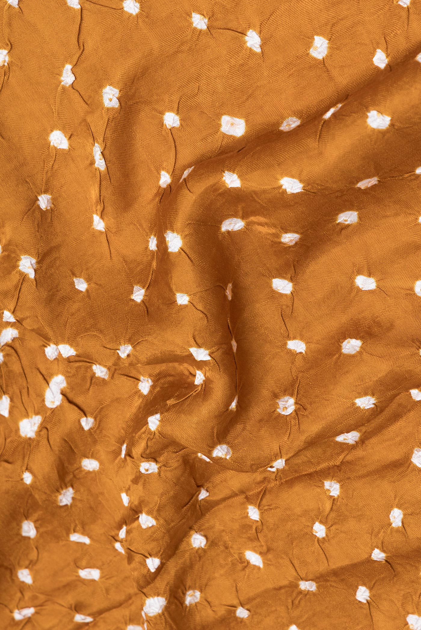 Close up of Mustard Blended Satin Crepe Saree with Bandhani Print on the body and Printed Border.  displaying folds