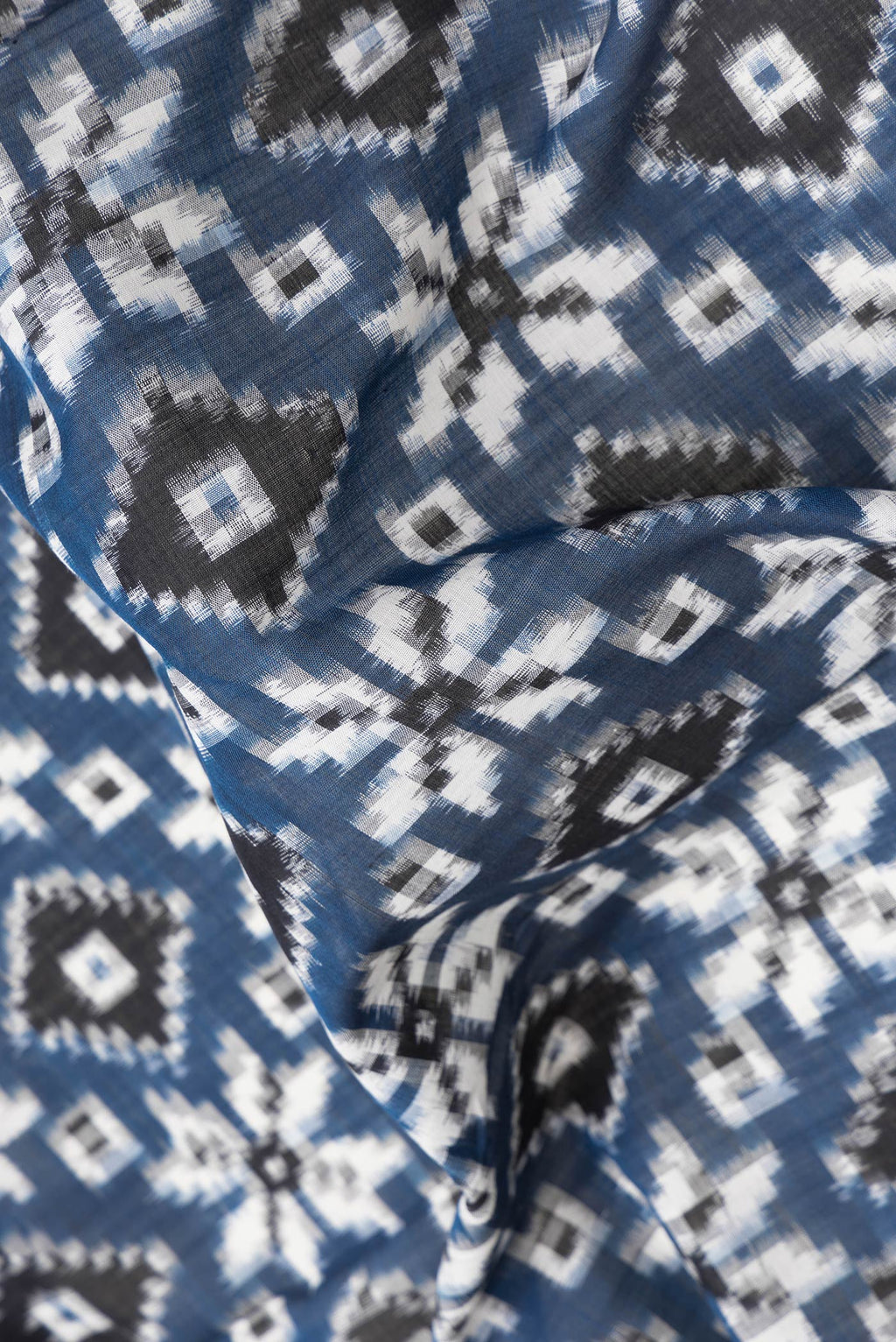 Close up of Blue Dual Tone Double Ikat Saree with Ikat Print on the body and Thread Border.  displaying folds