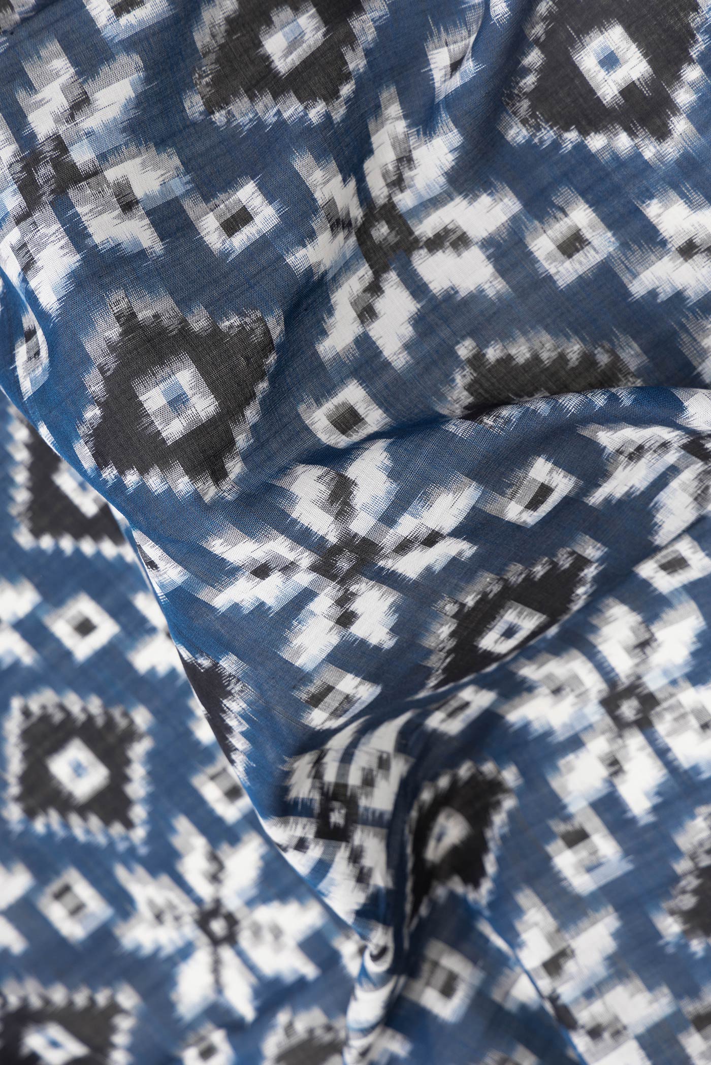 Close up of Blue Dual Tone Double Ikat Saree with Ikat Print on the body and Thread Border.  displaying folds