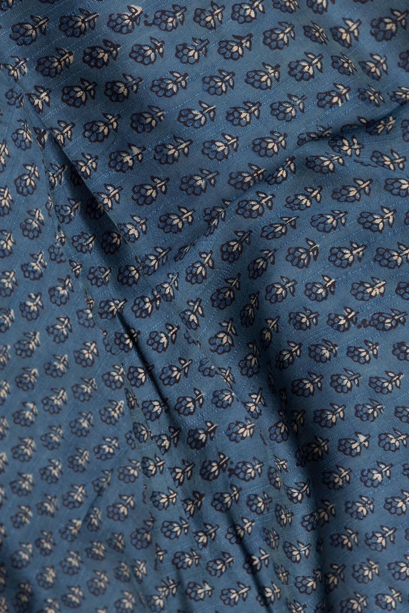 Close up of Blue Grey Dual Tone Tussar Silk Saree with Printed design on the body and Zari Border.  displaying folds