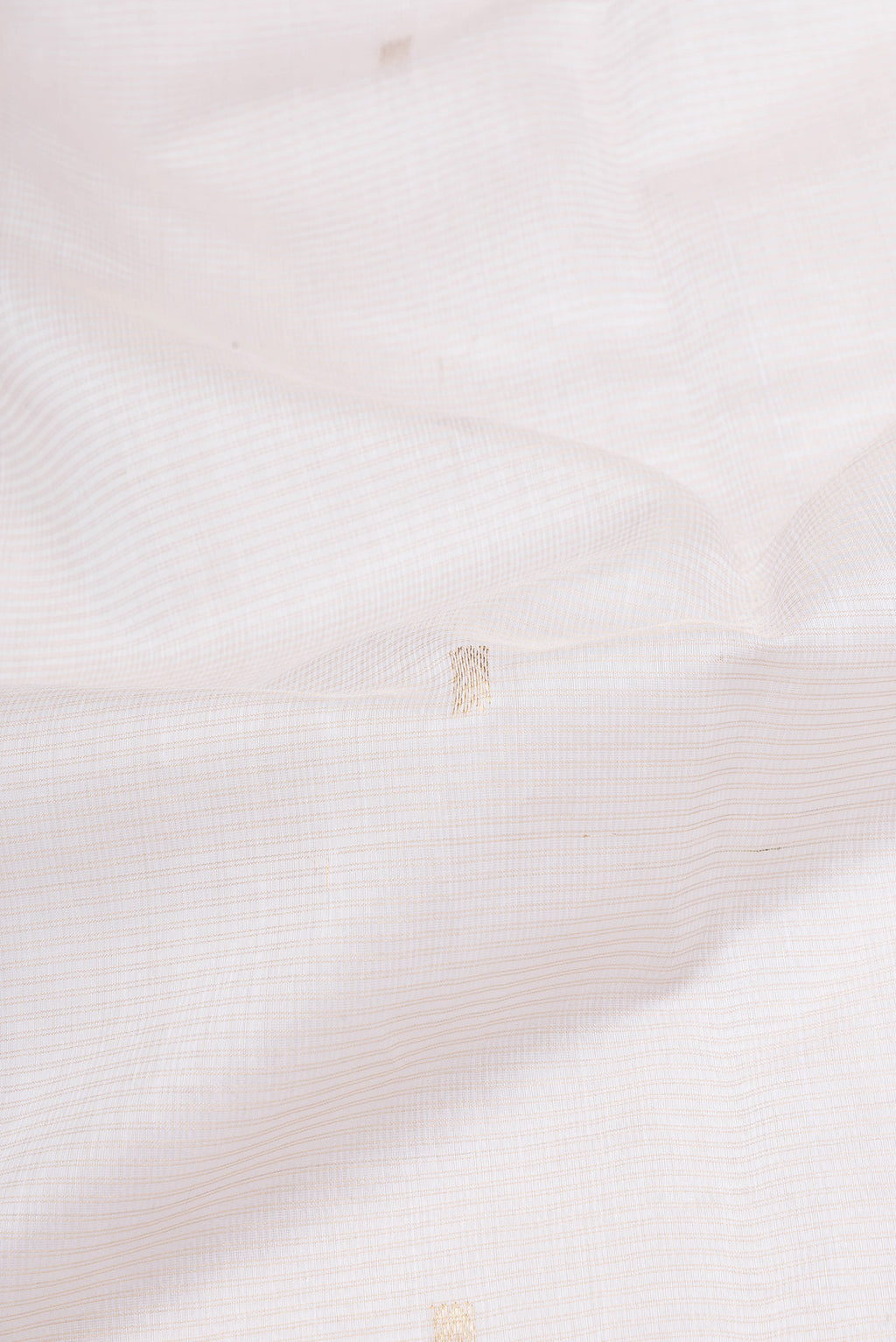 Close up of Off White Maheshwari Silk Cotton Saree with Zari Butta on the body and Zari Border.  displaying folds