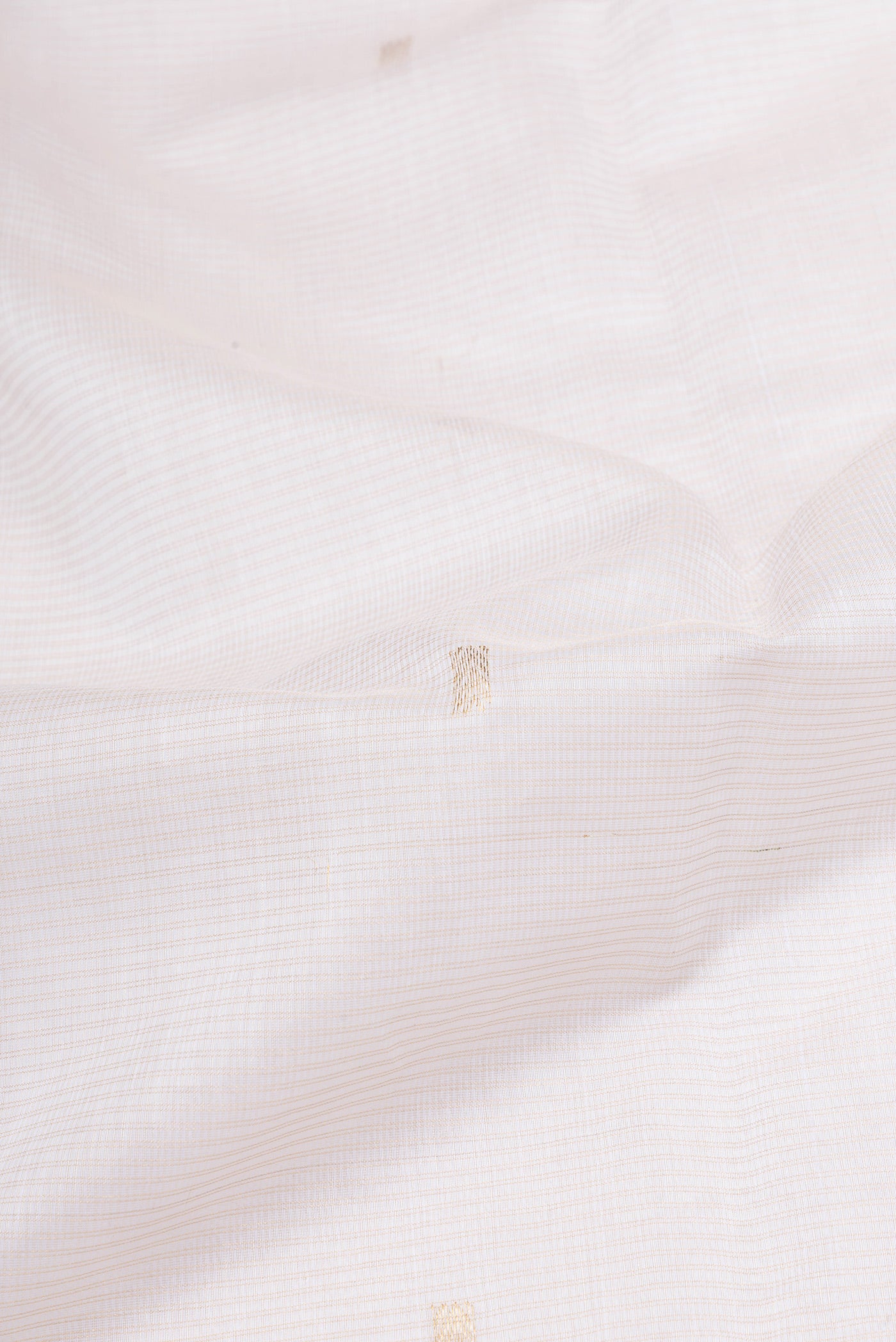 Close up of Off White Maheshwari Silk Cotton Saree with Zari Butta on the body and Zari Border.  displaying folds