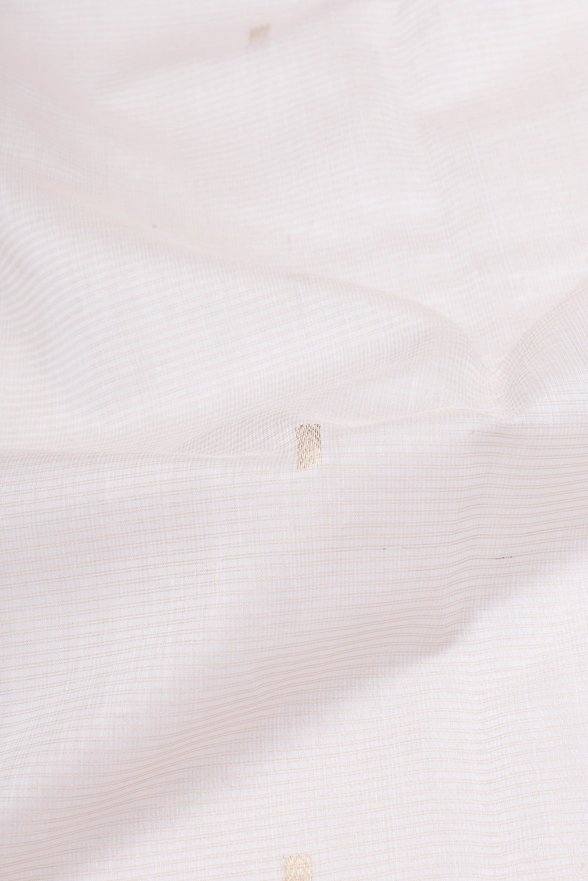 Close up of Off White Maheshwari Silk Cotton Saree with Zari Butta on the body and Zari Border.  displaying folds