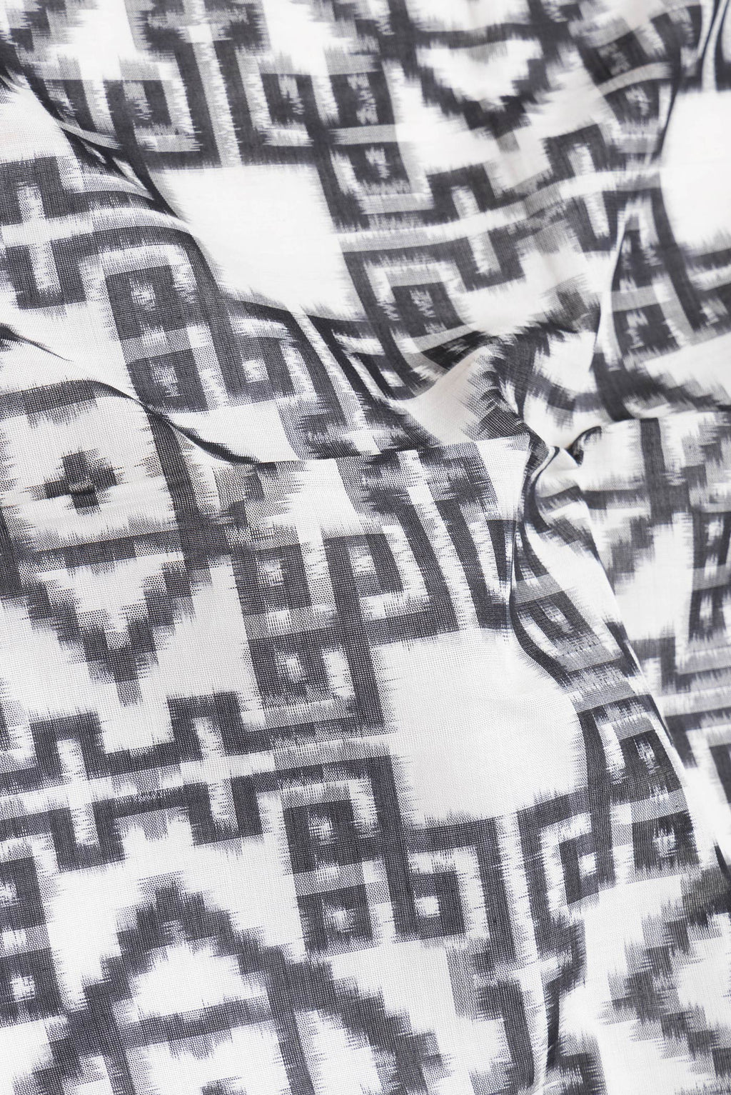Close up of Black and White Color Double Ikat Saree with Ikat Print on the body and Thread Border.  displaying folds