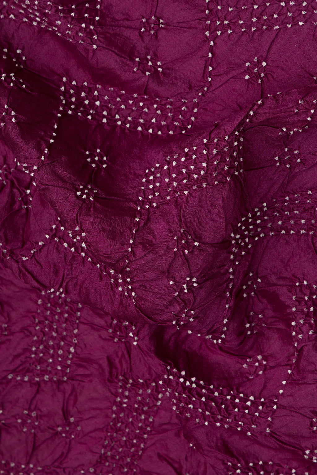 Close up of Pure Silk Magenta Bandhani Saree with Bandhani Print on the body and Without Border.  displaying folds