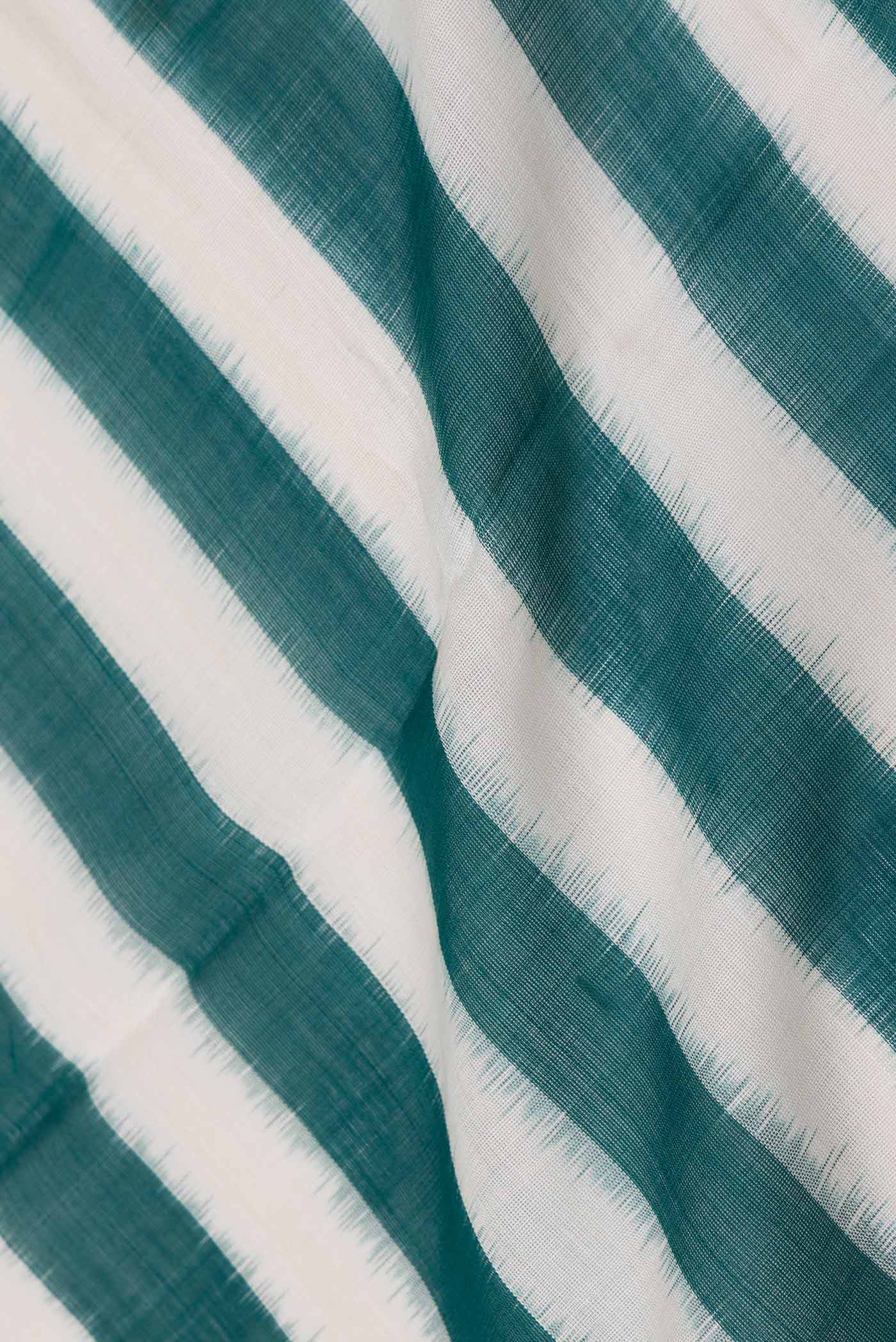 Close up of Green and Off  White Color Double Ikat Saree with Stripes on the body and Plain Border displaying folds
