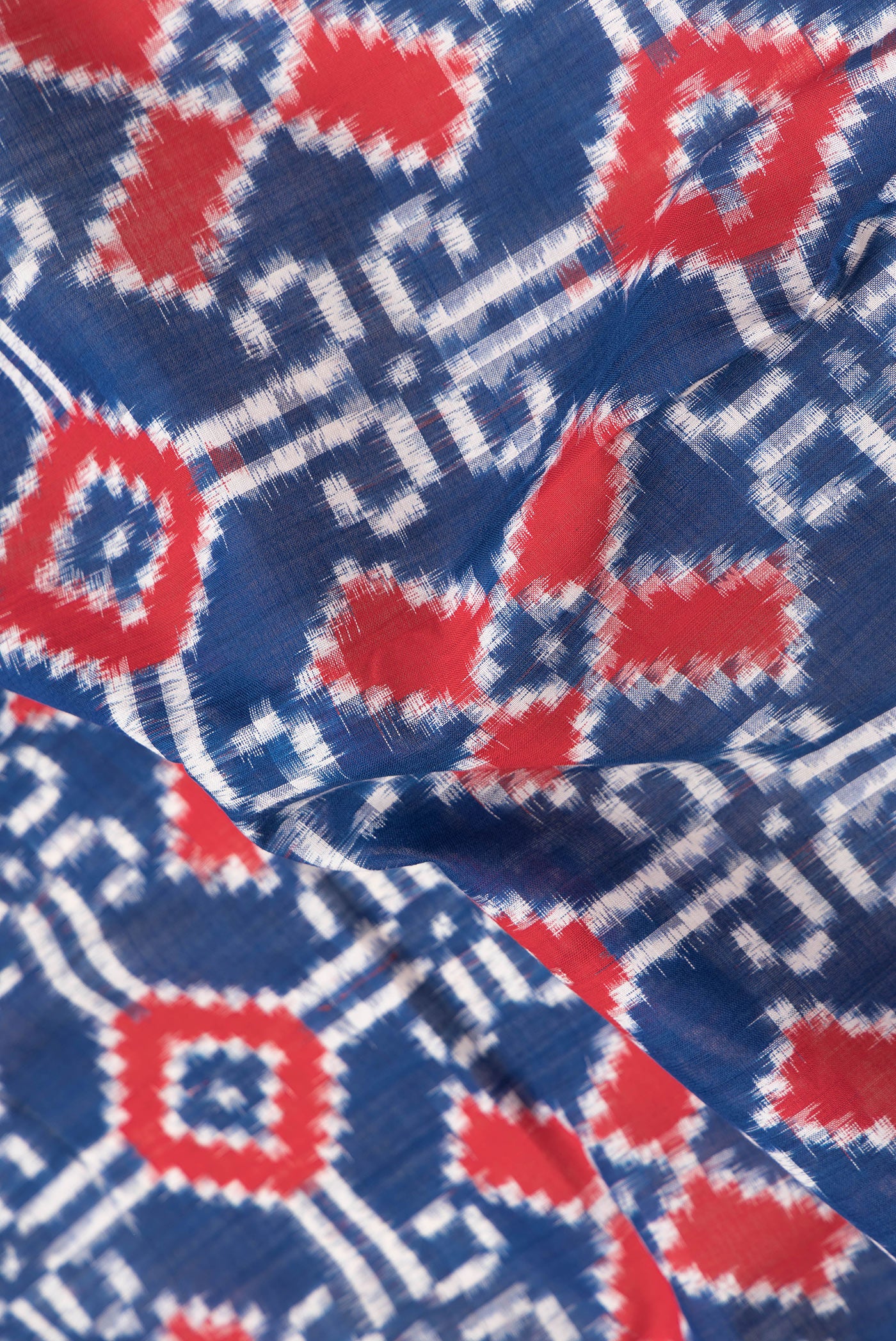 Close up of Navy Blue Dual Tone Double Ikat Saree with Ikat Print on the body and Thread Border.  displaying folds