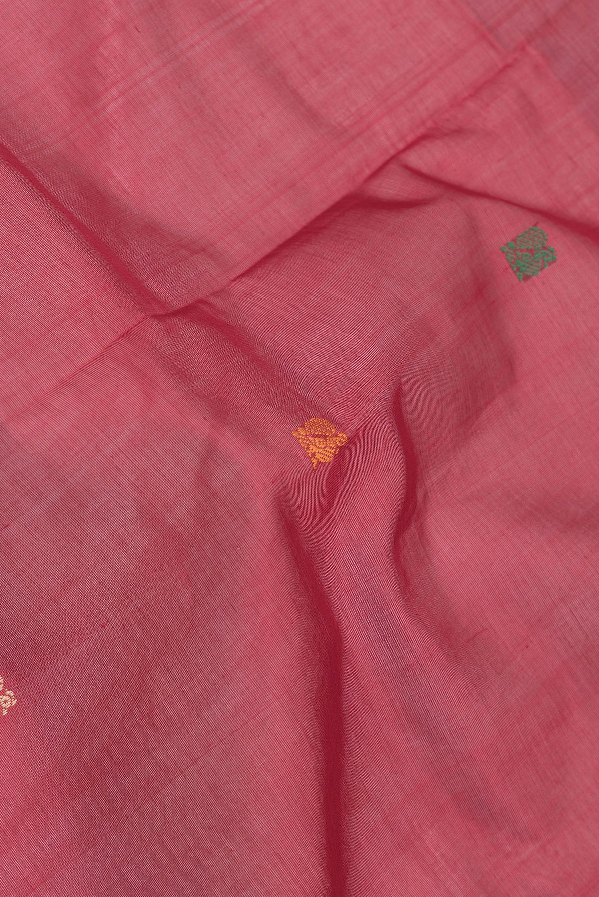 Close up of Red Dual Tone Silk Cotton Saree with Thread Butta on the body and Thread Border.  displaying folds