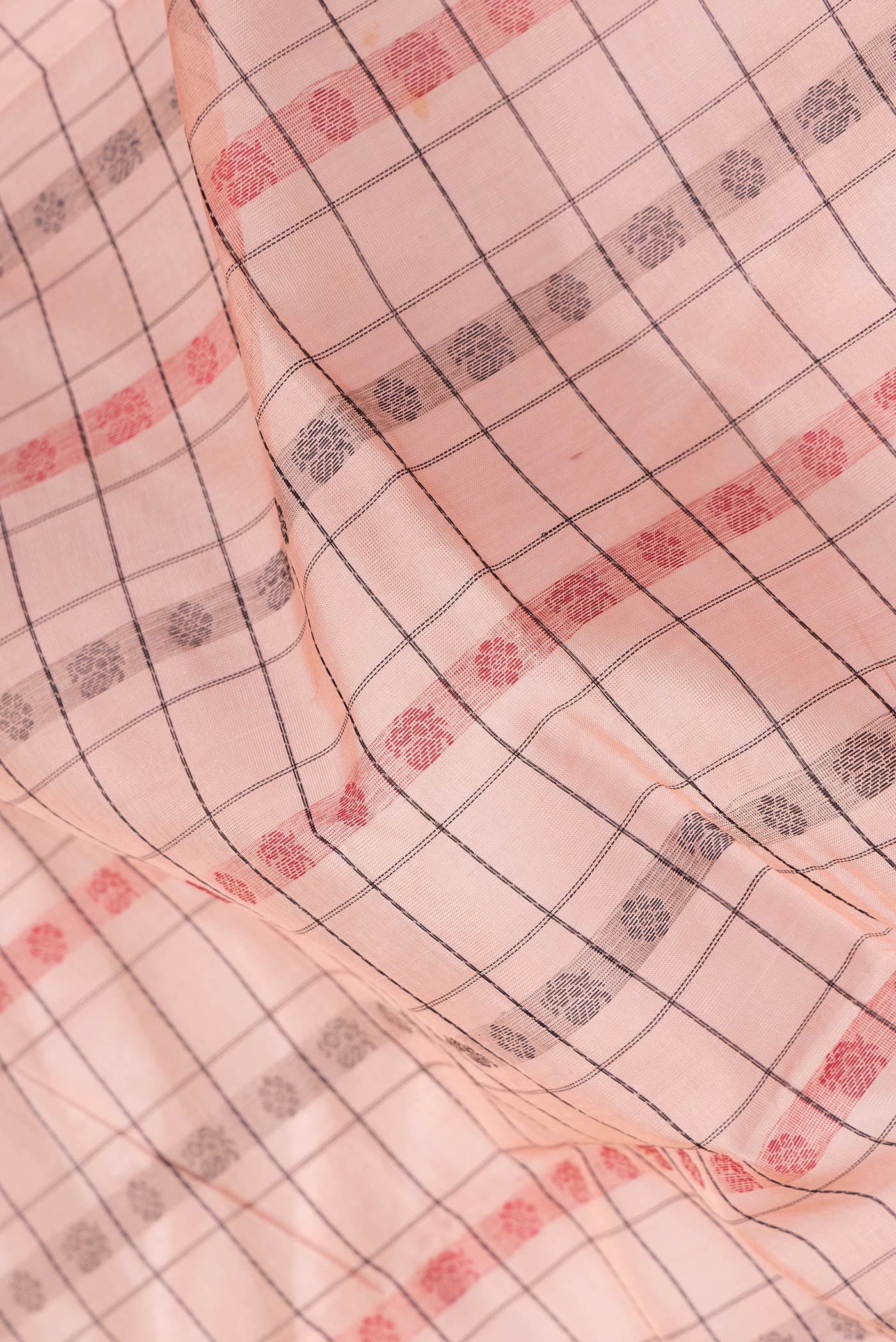 Close up of Peach Dual Tone Silk Cotton Saree with Thread Butta on the body and Zari Border.  displaying folds