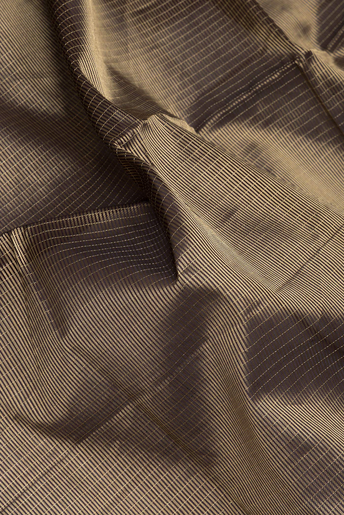 Close up of Coffee Brown Dual Tone Silk Cotton Saree with Checked design on the body and Zari And Thread Border.  displaying folds