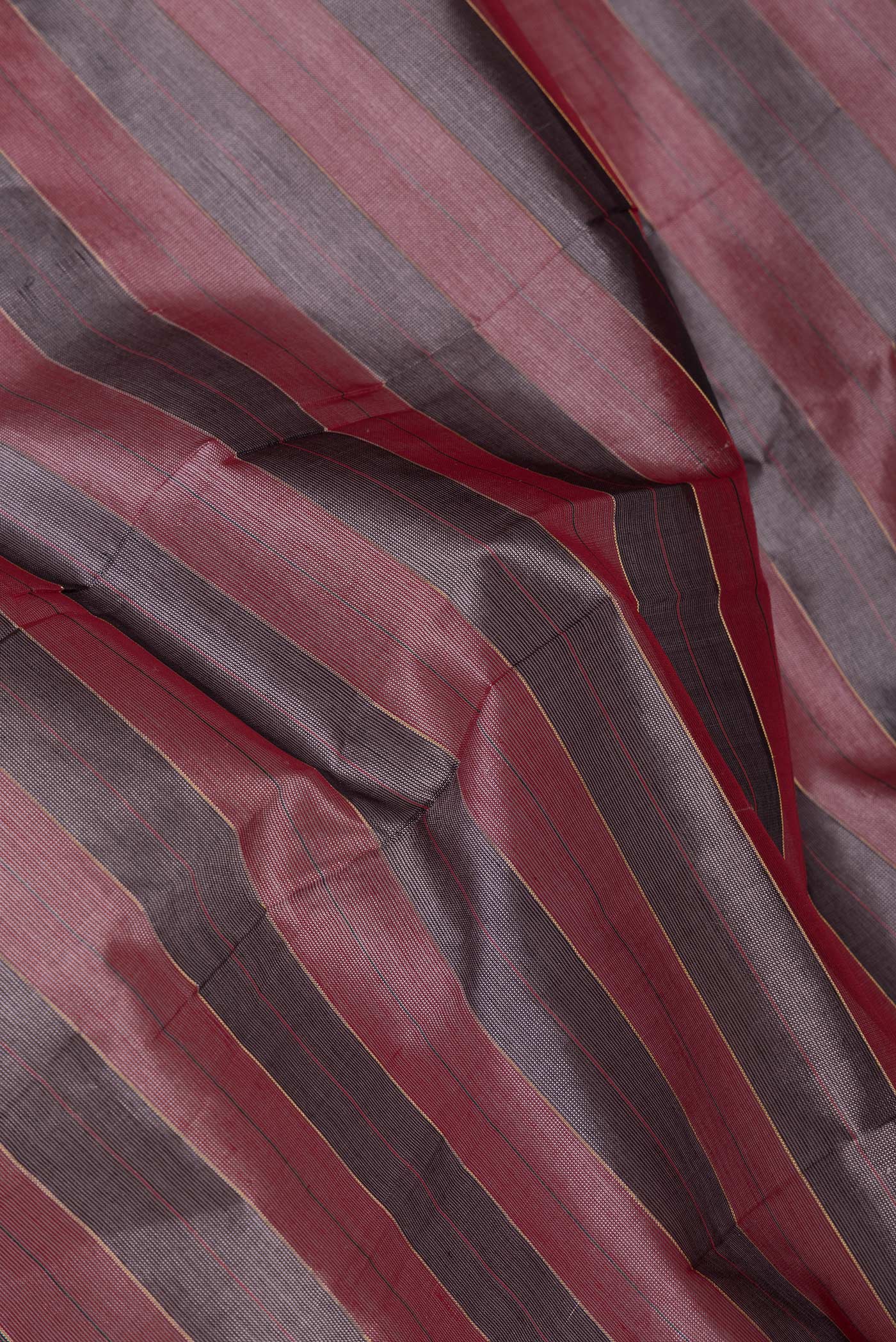 Close up of Grey and Pink Color Silk Cotton Saree with Stripes on the body and Zari Border.  displaying folds