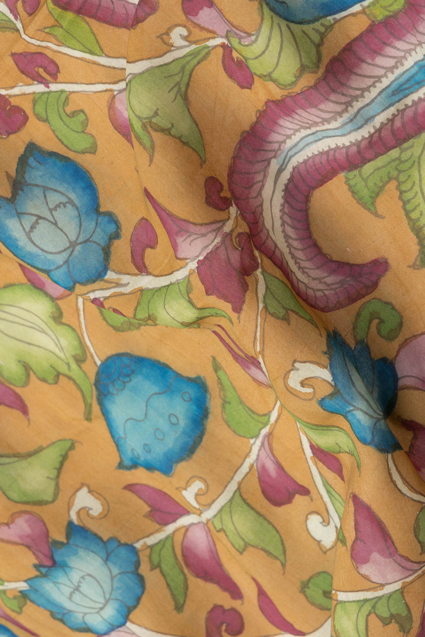 Close up of Mustard Dual Tone Tussar Silk Saree with kalamkari Print on the body and Zari Border.  displaying folds