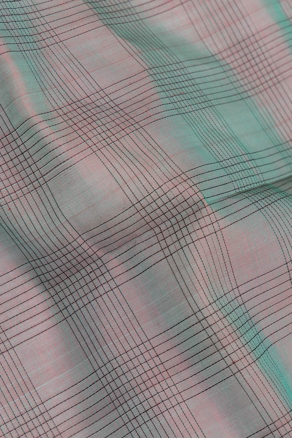 Close up of Green Dual Tone Silk Cotton Saree with Checked design on the body and Zari And Thread Border.  displaying folds
