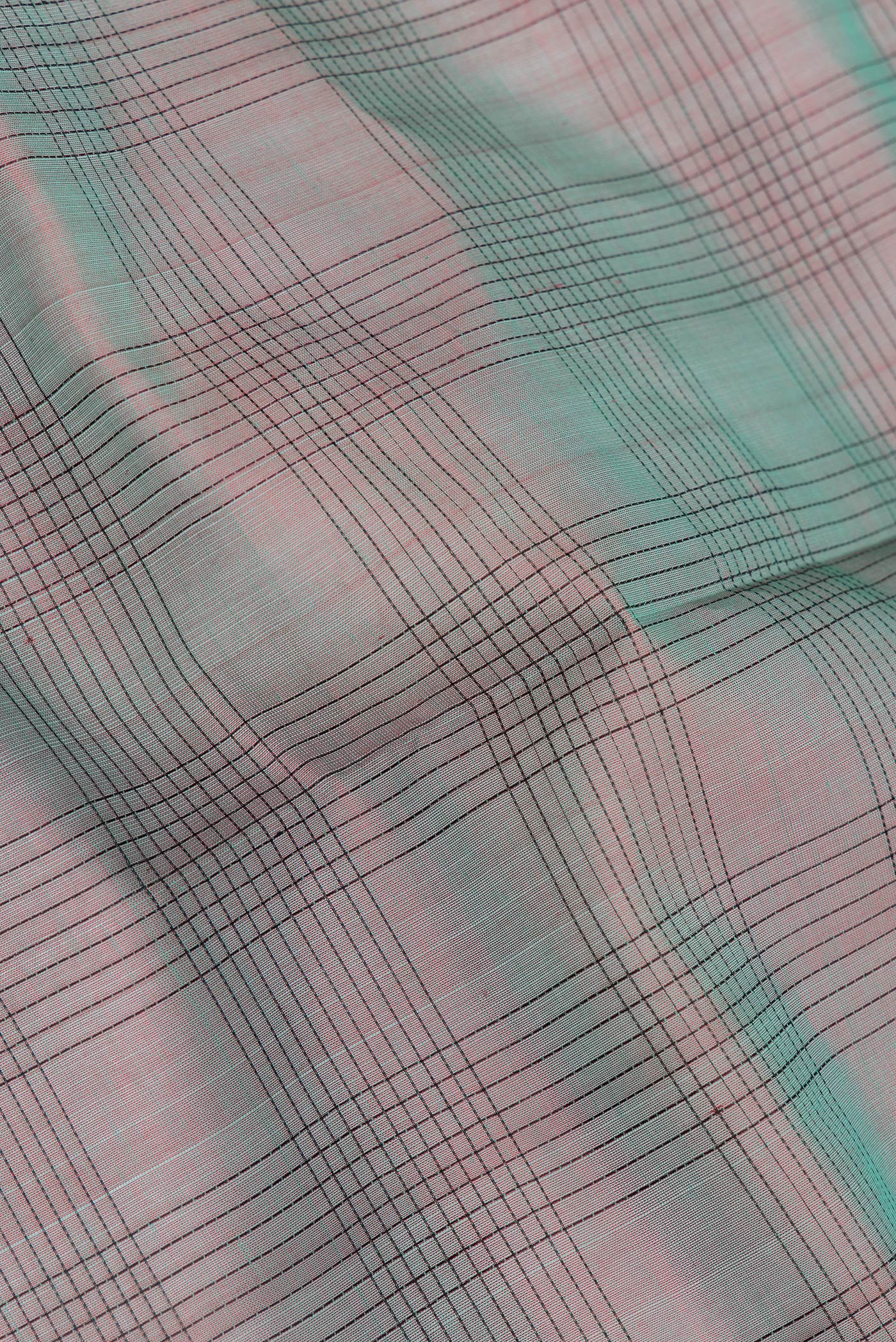 Close up of Green Dual Tone Silk Cotton Saree with Checked design on the body and Zari And Thread Border.  displaying folds