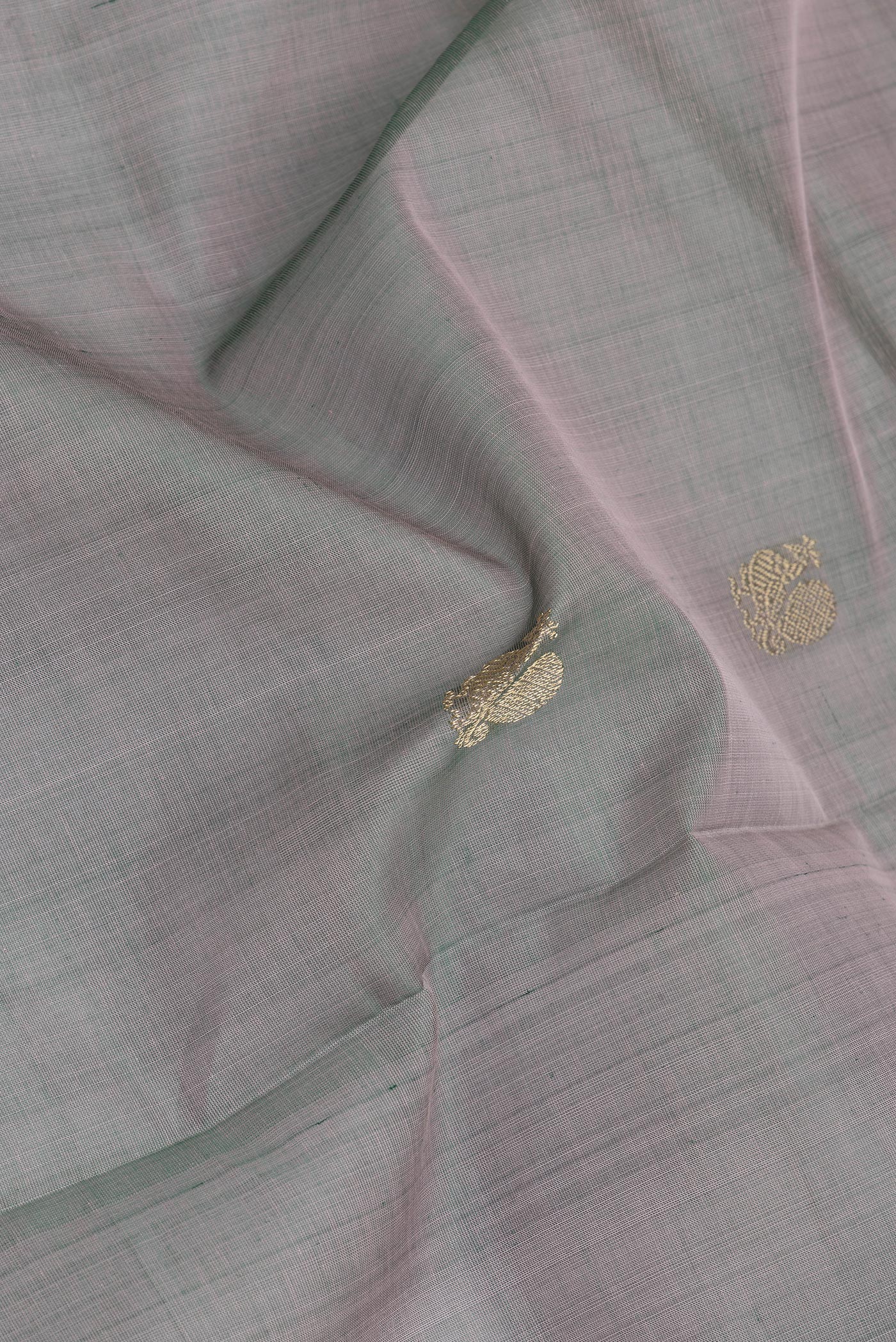 Close up of Grey with Green Color Silk Cotton Saree with Zari Butta on the body and Zari Border.  displaying folds