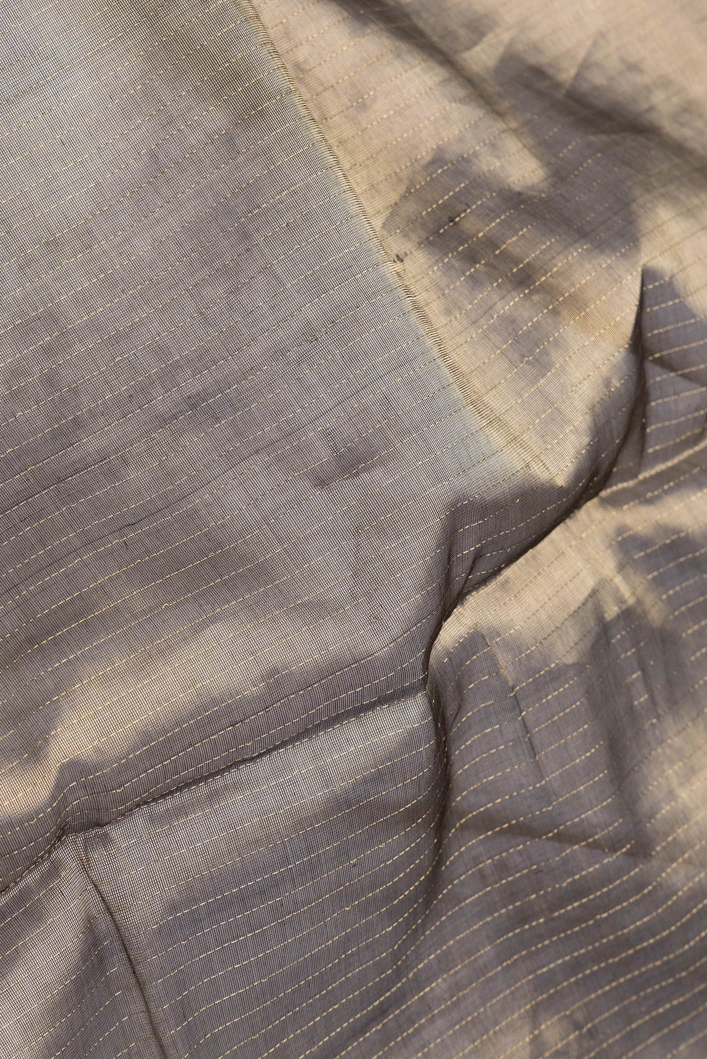 Close up of Brown Dual Tone Silk Cotton Saree with Stripes on the body and Zari And Thread Border.  displaying folds
