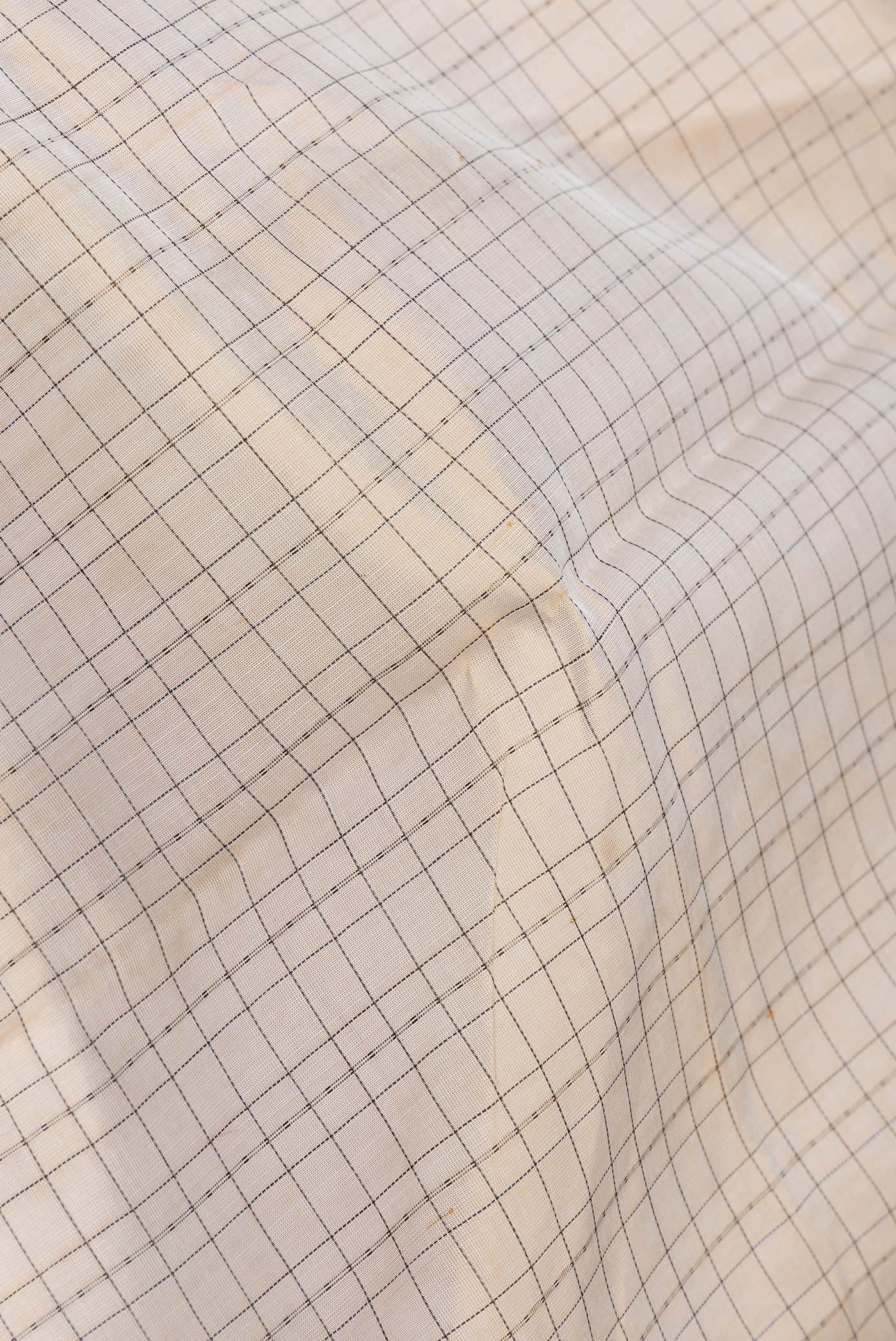 Close up of Gold Dual Tone Silk Cotton Saree with Thread Butta on the body and Zari Border.  displaying folds