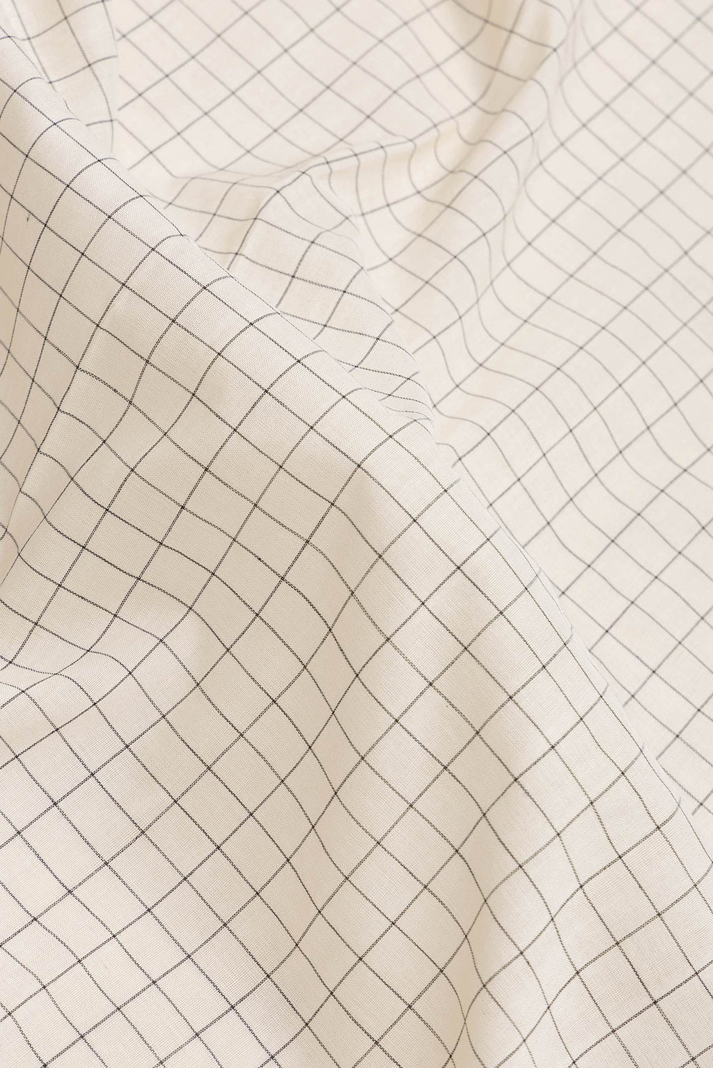 Close up of Off White Dual Tone Double Ikat Saree with Checked design on the body and Ikat Border.  displaying folds