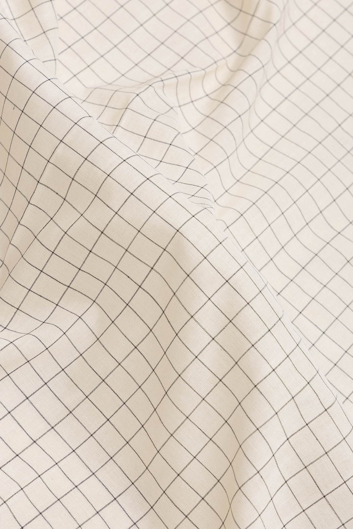 Close up of Off White Dual Tone Double Ikat Saree with Checked design on the body and Ikat Border.  displaying folds