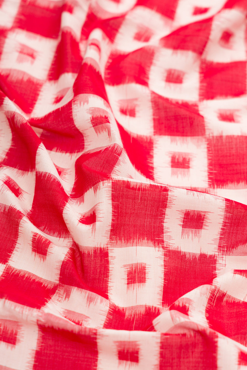 Close up of Red Dual Tone Double Ikat Saree with Ikat Print on the body and Plain Border.  displaying folds